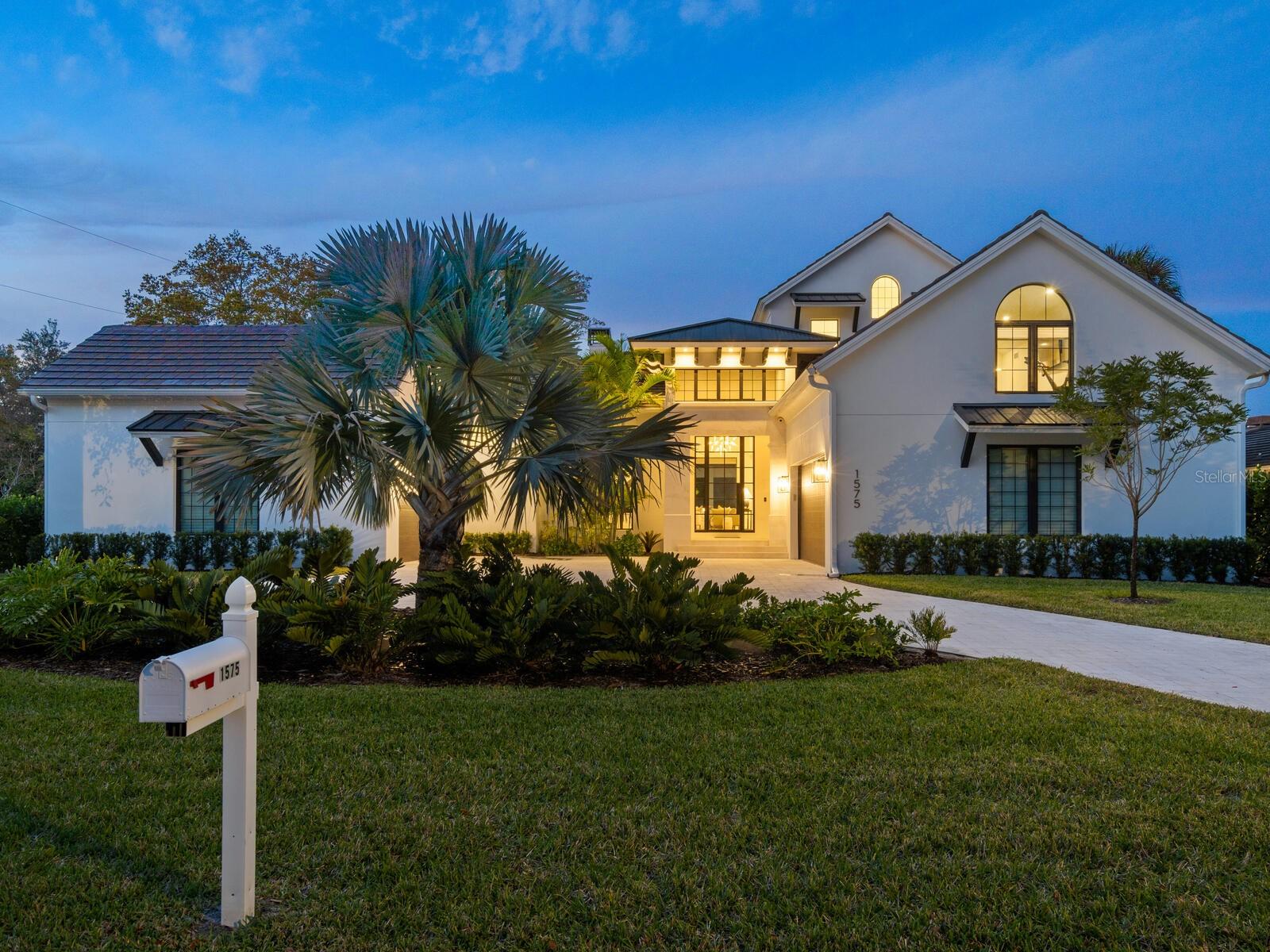 Built in 2022 with the finest finishes and exquisite coastal design, this modern home is a perfect blend of new luxury and Old Florida character in an ideal West of Trail location with private canal access to Sarasota Bay and immediate proximity to exceptional schools, world-famous beaches, and countless community amenities. Pristine inside and out with all hurricane impact glass and the highest end custom features, this sprawling home is excellently laid out to maximize privacy within and from neighboring lots. 
Past the circular drive, the main entrance is flanked by separate garages that open to a meticulous stone-paved courtyard with estate-like elegance continuing to the double-height entry vestibule and oversized glass front door. Soaring ceiling heights and abundant natural light are immediate impressions in the open layout of the ground floor, brilliantly conceived to preserve incredible sight lines and also allow for private work space and discrete storage and utility. The great room is the epitome of comfortable elegance, with a natural stone-clad gas fireplace and a wall of glass sliders that open to the poolside terrace. The adjacent kitchen boasts two massive islands for incredible entertaining and prep space, with two Subzero refrigerators, drawer microwave, double-width sink with two faucets, and six-burner Wolf gas range. Out of sight, a spacious butler’s pantry extends from the main kitchen with additional oven and counter and storage space. Beyond the kitchen, the dining area easily accommodates eight or more and is surrounded by oversized sliding glass doors that open both to the poolside terrace and the dedicated outdoor dining room with fully equipped summer kitchen that includes grill and stainless vent hood, sink and beverage refrigerator.
The first floor owners’ suite is a luxurious retreat accessed by a private hallway that opens to an enormous bedroom with large doors to an outdoor lounge area and the main terrace. The spa-like bathroom encompasses a massive glass-enclosed walk-in shower with rain head and free-standing soaker tub, two large vanities, and separate water closet. On the other side of the home, a spacious casita beyond the outdoor dining room opens to a private media den overlooking the pool and leading to a magnificent guest suite with vaulted ceiling and resort-style bathroom. Upstairs, two en suite bedrooms add plush accommodations ideal for family living or hospitality. Additional enhancements in this home include a den ideal for a music room or personal study, a second-floor beverage station with refrigerator and generous cabinet space, bespoke gym with full mirror wall, cushioned floor, and high-powered fans, and a laundry room with dual stack washer-dryer units and plentiful counter space and storage. 
Outside, a unique pool enclosure adds to the home’s architectural distinction, beautifully extending the living space without obstructing views of the landscape and waterfront. The heated saltwater pool and spa with waterfall feature are surrounded by a tiled terrace that echoes the premium interior style. Beyond the terrace, a manicured lawn leads to 100 feet of private waterfrontage with a 10’ dock and a 10,000 lb boat lift for direct access to Sarasota Bay and the Gulf. Enviably located West of Trail in the well-maintained Cherokee Park community just above the north bridge to Siesta Key, this new build home is a masterpiece of coastal luxury. Furnishings available separately. Room Feature: Linen Closet In Bath (Primary Bedroom).