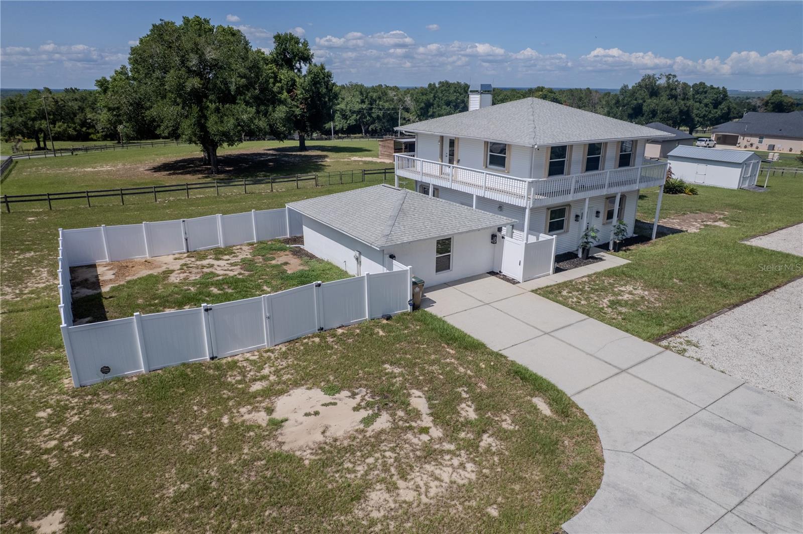 Perched on 5 FULLY FENCED ACRES in the highly sought-after Sugarloaf Highlands community, this extraordinary estate offers a rare combination of LUXURY RENOVATIONS, a massive custom workshop, equestrian amenities, and exceptional FLEXIBILITY. Nestled within the rolling hills of the Sugarloaf Mountain region—one of Florida's highest elevations—this unique property provides the PRIVACY, FREEDOM, and SPACE that are becoming increasingly difficult to find.

Originally custom-built and extensively renovated, the home has been transformed into a bright, OPEN-CONCEPT RETREAT designed for both everyday living and entertaining. Public records reflect a 3-bedroom, 2-bath home. The current owners reimagined the upper level into an EXPANSIVE OWNER'S RETREAT, creating a spacious and flexible layout while preserving the home's unique character.

At the heart of the home is an OVERSIZED GRANITE ISLAND that anchors the gathering space and flows seamlessly into the chef-inspired kitchen featuring premium KITCHENAID STAINLESS STEEL APPLIANCES, a handcrafted COPPER FARMHOUSE SINK, and abundant workspace. The spacious living area is highlighted by a WOOD-BURNING STOVE with INTEGRATED COOKTOP, while windows and abundant natural light create a bright and inviting atmosphere throughout.

Occupying the entire upper level, the private owner's retreat serves as a peaceful sanctuary complete with WRAPAROUND BALCONY access overlooking the surrounding countryside and distant lake views. The elevated location provides beautiful sunset views and refreshing year-round breezes. The spa-inspired primary bath features a custom OVERSIZED SHOWER with DUAL SHOWER SYSTEMS, BODY SPRAY JETS, DUAL VANITIES, and elegant finishes. The guest bath offers a handcrafted COPPER SINK and relaxing SPA SOAKING TUB.

The property is equipped to support a wide variety of lifestyles and allows vehicles, trailers, and equipment to access virtually every area of the acreage with ease. Horse enthusiasts will appreciate the FENCED PASTURES, mature SHADE TREES, and custom-built HORSE STABLE with enclosed TACK ROOM. 

One of the property's most impressive features is the OVERSIZED CUSTOM-ENGINEERED METAL GARAGE and workshop. Designed with high-clearance ceilings, electrical service, and abundant storage capacity, the structure easily accommodates boats, trailers, heavy equipment, car collections, workshops, and more. RV owners will also appreciate the existing RV HOOKUP with electric, water, and septic connections already in place.

Adding even more versatility, a detached AIR-CONDITIONED STUDIO/FLEX BUILDING offers ideal space for a home office, creative studio, hobby room, guest accommodations, or future in-law suite. Additional improvements include DUAL 220-VOLT ELECTRICAL HOOKUPS,  whole-house surge protection, lightning protection systems, STORM SHUTTERS, GENERATOR-READY PROPANE INFRASTRUCTURE, a COMMERCIAL-GRADE WELL SYSTEM, SECURITY SYSTEM, and a CUSTOM ELECTRIC GATED ENTRANCE.

Conveniently located near shopping, dining, medical facilities, major roadways, and the SCENIC GREEN MOUNTAIN AREA, this exceptional property offers the perfect balance of peaceful country living and modern convenience. Whether you're seeking a luxury country estate, equestrian property, mini-farm, workshop enthusiast's dream, or simply room to live life on your own terms, this remarkable property delivers a lifestyle UNLIKE ANYTHING ELSE CURRENTLY AVAILABLE.