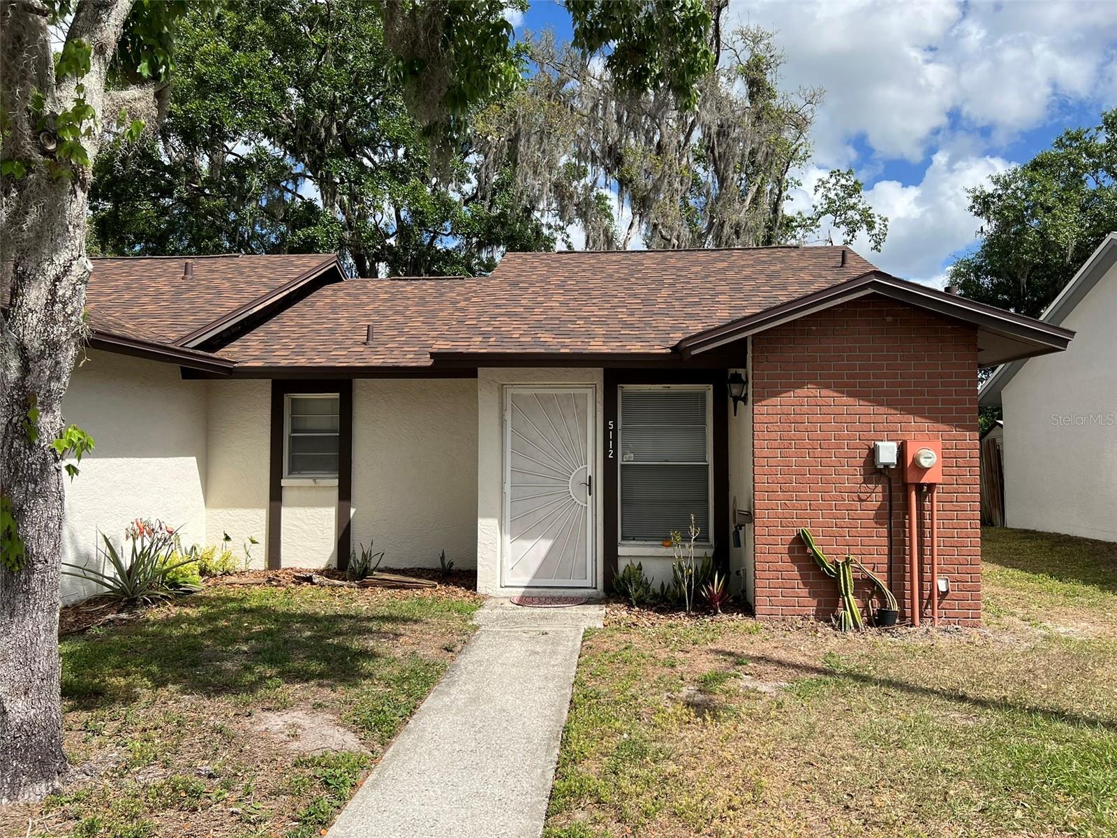 1 Bedroom, 1 bath townhome conveniently located just east of USF, close enough to avoid campus parking fees.  An open floor plan with vaulted ceilings gives that extra spacious feeling.  The great room features a wood burning fireplace and opens through sliding glass doors to a covered 14’x13’screened porch with a 6’ privacy fence around the rear yard…leaving just enough room to exercise a green thumb without turning it into a chore (ideal for pets, too!). A solar tube in the great room provides additional natural light, a real plus since the rear yard is very shady.  The kitchen has a pass through breakfast bar with room for a couple of barstools for casual dining Ceramic tile flooring in the living area, kitchen, and bath offer ease of maintenance, laminate flooring in the bedroom is just a little warmer underfoot.  The kitchen has an eat-in area that will accommodate a small table and chairs and has a stackable washer and dryer in a closet.  New roof completed in February 2022, new HVAC and ductwork in July 2025.  The community features an open-air pool with a covered picnic area, restrooms, and two racquet ball courts.  The location can’t be beat, it offers easy access to both I-75 and I-275 for those longer trips, and close by are USF, the VA Hospital, Advent Hospital and all the surrounding medical facilities.