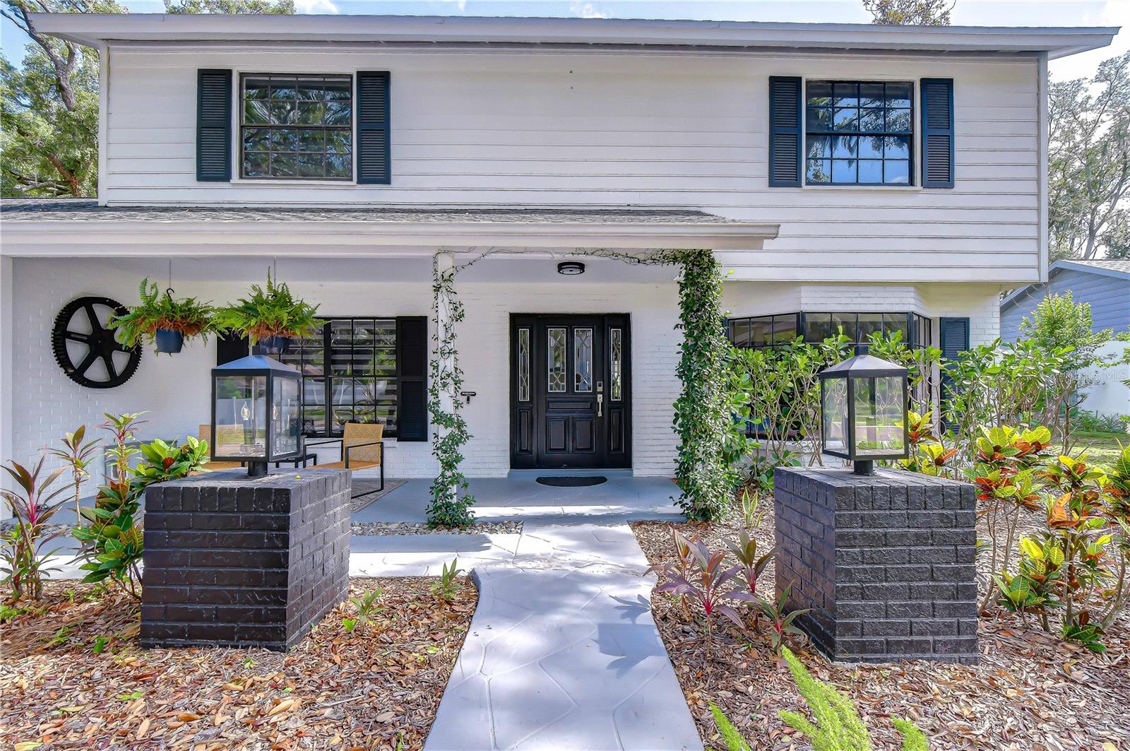 Magazine-worthy design, exceptional craftsmanship, and resort-style outdoor living come together in this breathtaking Bloomingdale estate. From the moment you arrive, the expansive covered front porch, framed by lush tropical landscaping, creates a striking first impression and sets the stage for what awaits inside. Completely reimagined with no detail overlooked, this home showcases designer finishes at every turn—from the statement lighting and custom staircase tile to the exquisite millwork and thoughtfully curated selections throughout. Step inside to an inviting open floor plan where your eyes are immediately drawn to the sparkling pool and picturesque backyard beyond. The elegant living and dining rooms are designed for both everyday comfort and effortless entertaining, featuring a cozy fireplace, bay window, beautiful custom tile flooring, and timeless wainscoting. Just off the main living area, a spacious flex room offers endless possibilities as a home office, library, or creative space. The stunning chef's kitchen is truly the heart of the home, boasting premium Viking appliances, dramatic waterfall-edge quartz countertops, a porcelain farmhouse sink overlooking the backyard, abundant cabinetry, and exceptional workspace for cooking and gathering alike. Upstairs, the luxurious primary suite serves as a private retreat with French doors, oversized windows that fill the room with natural light, an expansive walk-in closet, and a spa-inspired en-suite featuring designer tile, dual quartz vanities, and high-end finishes. Three additional generously sized bedrooms share a beautifully remodeled bathroom complete with custom cabinetry and a shower/tub combination. Adding even more flexibility, the Florida room is perfectly suited as a home gym, media room, playroom, or additional family room to fit your lifestyle. Step outside into your own private resort. The oversized heated pool and spa are surrounded by an incredible outdoor living space featuring a stacked-stone fire pit with built-in seating, creating the perfect setting for relaxing evenings or unforgettable gatherings. With ample room to park a boat or RV and no HOA or CDD restrictions, this property offers the freedom and flexibility that's increasingly hard to find.