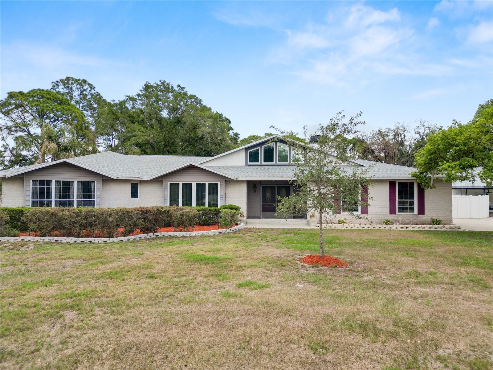 Welcome to your private slice of paradise in the heart of South Lakeland! This large 3 bedroom 2.5 bath, South Lakeland home comes with a den and a flex room that can be used as an extra bedroom, office or mutli-functional space. The home is nestled on an expansive 1.67-acre lot in a beautifully well maintained neighborhood with NO HOA. The home also comes with a detached 1 bedroom, 1 bathroom apartment or in-law suite with it's own private entrance. This custom-built property offers the perfect blend of space, privacy, functionality, and income-producing potential.
The main home features over 3,500 square feet of living space with an inviting open layout, oversized rooms, and soaring vaulted ceilings that create a bright and spacious atmosphere throughout. The large great room flows seamlessly into the custom kitchen complete with neutral granite countertops, an extended breakfast bar, spacious island, gas range, built-in oven, and two oversized pantries featuring custom built-in organizers and pull-out drawers.
The spacious primary suite offers beautiful cherry wood flooring, a en-suite bath with raised cherry cabinetry, granite countertops, a large walk-in shower, and a walk-in closet with built-in organizers. One of the guest bedrooms includes its own private half bath, while the dedicated home office features a private space with French doors that will allow you to work from home without any interruptions. There is also a versatile bonus room ideal for a gym, media room, playroom, or additional flex space.
Step outside and enjoy the peaceful outdoor living areas including a screened deck with hot tub and an additional screened patio overlooking the expansive property. Car enthusiasts, hobbyists, and business owners will appreciate the incredible garage and storage capacity including a 2-car attached garage, massive 4-car detached workshop with electric, workbenches, and loft storage, plus an additional 3-car carport.
One of the standout features of this property is the detached 1-bedroom apartment with its own private entrance and separate A/C system. Complete with a living room, spacious kitchen, dinette area, bedroom, and full bath, this space offers excellent income-producing potential, multigenerational living options, guest accommodations, or a private home office setup.
Opportunities like this are rare in Lakeland — offering acreage, privacy, a spacious custom home, incredible storage and workshop space, and an income-producing detached apartment all in one exceptional property.