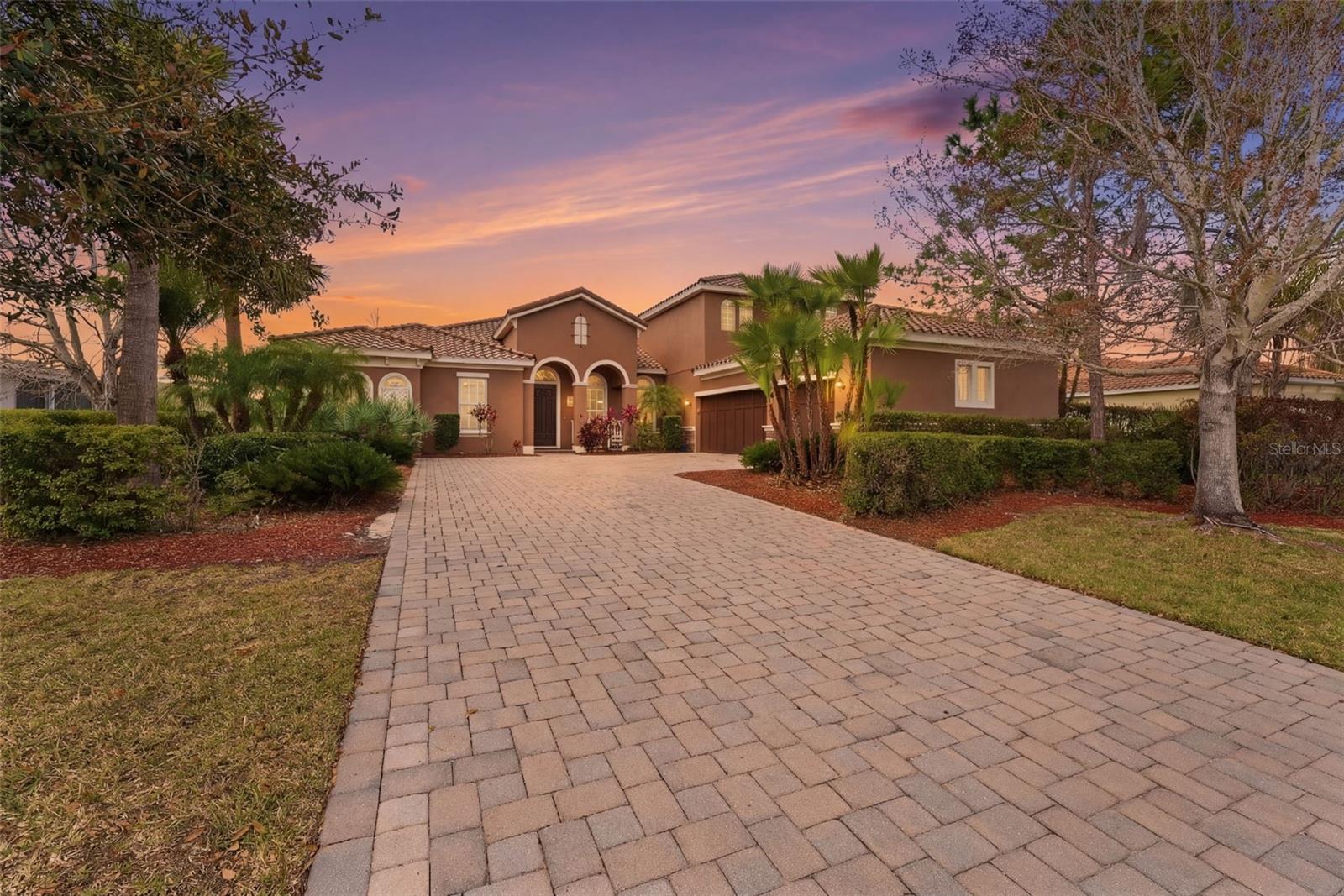 Virtually Staged. Well-appointed and upscale , this casually elegant two-story Rye Wilderness home offers nearly 4,000 square feet of thoughtfully designed living space. The layout includes a versatile flex-suite that functions beautifully as a secondary primary bedroom, private guest quarters, or even an au pair unit. Step inside and let me walk you through a home that blends Mediterranean-inspired style with comfortable everyday living.As you enter, you’re greeted by an expansive, light-filled living area with a floor plan that introduces the formal dining room, main living room, and a welcoming hallway drawing you into the heart of the home. Generous windows and glass doors invite in soft natural light while preserving comfort, creating a bright, airy feel without harsh heat. Straight ahead, your eye is drawn to the lanai and pool, visible the moment you walk in, setting a relaxed  tone.The classic masonry construction, elegant stone accents, and tile roof frame a warm interior centered around a fully equipped kitchen with an eat-in area perfect for daily meals. You’ll find ample cabinetry, a built-in pantry, double sink with disposal, and convenient access to the oversized family room. The large family room, anchored by another wall of sliding glass doors, opens to the lanai so you’re never far from tranquil views of the pool.
The pool has with a gentle beach-entry design that offers a gradual slope into the water and a spa with a waterfall feature that enhances the soothing atmosphere. The expansive, travertine-tiled lanai provides abundant room for lounging, dining, and entertaining, making it an ideal place for everyday relaxation as well as gatherings.
A practical first-floor layout places two secondary bedrooms just off the kitchen, with a well-situated bathroom between them—perfect for morning routines or guest use. 
Storage is a true strength on this level: in addition to the kitchen pantry, there is storage in the laundry room, a hall closet that can serve as a guest or coat closet, and a remarkable under-stairs walk-in storage area accessed from one of the bedrooms.Another comfortable first-floor bedroom with its own private bath and generous closet creates an excellent guest suite, older-child retreat, or private home-office bedroom.
At the opposite side of the main living spaces, a more private hallway transitions you into the owner’s wing. Just before the primary suite, a flexible room works beautifully as a nursery, office, sitting room, dressing room, or creative studio space. The primary bedroom is spacious and serene, and opens to the lanai and pool, allowing you to enjoy the water and waterfall feature. The primary bath offers a spa-like experience with a large walk-in shower, separate soaking tub, dual vanities, private water closet, and a generously sized walk-in closet.
Upstairs, an expansive flex suite opens a world of possibilities. Currently enjoyed as a gym and teen living space, it can easily serve many purposes.  With its own full bathroom, two closets. This level functions as a true separate living zone while still feeling connected to the home. Throughout, a thoughtful mix of tile, wood-look plank flooring, carpet, and travertine supports both style and practicality, allowing this floor plan to adapt gracefully to changing seasons of life while maintaining an easy, casually elegant ambiance.