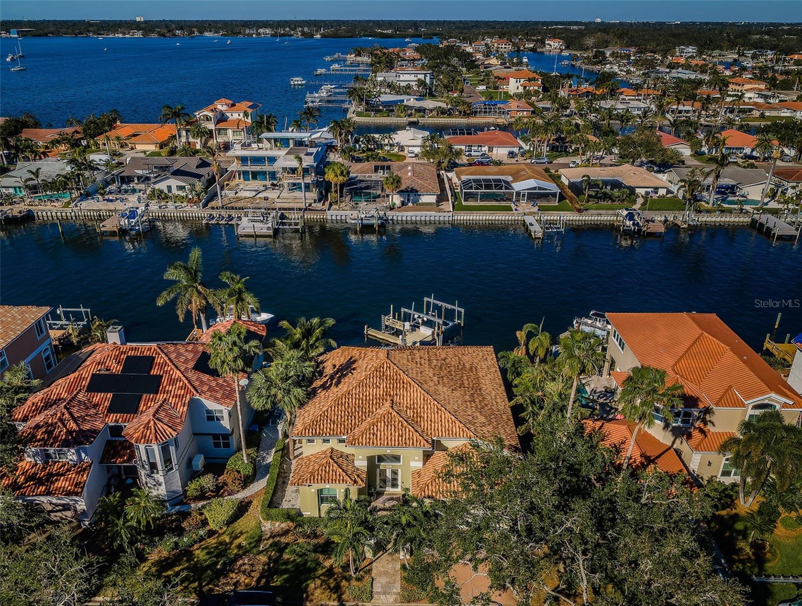 MOVE-IN READY! GORGEOUS CONTEMPORARY WATERFRONT ELEGANCE OFFERS BEAUTIFUL VIEWS AND AN UNFORGETTABLE LIVING EXPERIENCE! Impressive covered entry transitions to a soaring foyer and towering 19ft-high great room overlooking the waterfront. Elegant driftwood-style porcelain flooring and lovely modern lighting/fixtures give the home a distinctive luxury appeal. Great room features a built-in media center with soaring tumbled marble-façade, an array of tall windows overlooking the pool deck and waterfront, and a wonderful wine/beverage wetbar with glass-enclosed wine wall. Resplendent gourmet kitchen boasts exquisite quartz surfaces, shaker-style coastal cabinetry, high-end Thermador appliances, gas cooking, built-in refrigeration, and an island prep center with large breakfast bar, sizable hidden pantry, and lovely tile backsplash. The exceptional indoor laundry provides quartz counters and cabinetry to match the kitchen, a built-in sink and generous storage. The owner’s suite is pure bliss: with a bedroom that opens to and overlooks the pool/waterfront, features an elaborate built-in cabinetry storage system with media center, and contains an outstanding walk-in closet system & substantial 2nd closet system. The owner’s bath is a posh, pampering sanctuary with elegant dual vanities, a richly-encased jetted spa Jacuzzi tub for two, and a magnificent zero-entry multi-head rainshower. Upstairs you’ll find 3 spacious, well-appointed bedrooms. All baths are beautifully finished with fine materials and custom features. The many luxury amenities of this remarkable home include whole-house lighting, electronic window treatments in bedrooms and extensive multi-media capabilities. Out back discover a dazzling waterfront paradise with gorgeous 250sqft covered deck with pool bath and large quartz bar overlooking the water. Superb outdoor kitchen enjoys fine quartz/tumbled marble finishes, Alfresco natural gas cooking center, and Subzero icemaker & refrigeration. Elegant travertine paver deck extends to a terrific built-in firepit and fabulous free-form heated & cooled pool/spa (with a private hot/cold water shower). The brilliant boat dock setup includes a 25,000lb boat lift with shore power/water, jetski lift, 2 kayak/paddleboard lifts, dock lighting, fish cleaning station and seating bench. Plush common areas share a lavishly-detailed clubhouse, billiards room, large fitness center w/his & her facilities, library, 3 pools, tennis courts & private beach – all at a surprisingly affordable monthly fee. Just 5 min to beaches, 10 min to downtown St. Pete and 25 min to Tampa Airport.