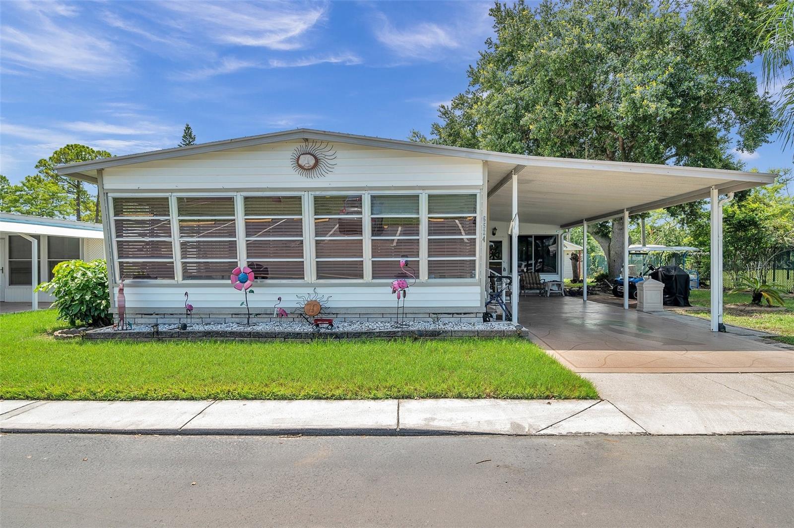 WELCOME TO YOUR HOME SWEET HOME at 6524 Roosevelt Dr, Port Richey in the gated community of Senate Manor, a 55+ cooperative community in SUNNY Florida. This 1980 DOUBLE-WIDE home with 2 bedrooms + FL room & 2 bathrooms lies on a nice lot with just over 5,250 sqft in a NO CDD zone. This home did experience storm surge from Hurricane Helene & it is being sold AS IS. Key exterior features are covered front porch where you can meet & greet your neighbors, 2 entrances into the home, rain gutters, carriage lights & easy-breezy TROPICAL landscaping that is taken care of for you. When you step inside, you'll LOVE the OPEN FLOOR PLAN consisting of the eat-in-kitchen, living & dining rooms & SPACIOUS lanai/Florida room. The Florida room in the front of the home spans the width of the double-wide home & features high ceiling & tile floors. Plywood subfloors are already installed, aiding in the restoration of the home. The primary bedroom has a private bathroom. The second bedroom with guest bathroom are near each other. The cool thing about renovating is that you can DESIGN your DREAM home. The CONVENIENT storage shed with laundry hookups is great for your garden tools or beach gear. Senate Manor is a GLORIOUS RESIDENT-OWNED 55+ COMMUNITY & included in the low HOA fee of $200/month is trash with recycling pick-up 2X week, all exterior lawn maintenance, water, sewer, street lights, water with fountain views, gates & recreational activities like HEATED POOL & SPA, shuffleboard, horseshoes & gym. There is optional storage for boats, RVs or trailers on site. Location is IDEAL near beaches, shopping, restaurants, medical plazas, places of worship & tourist attractions. MAKE THIS YOUR FUTURE HOME!