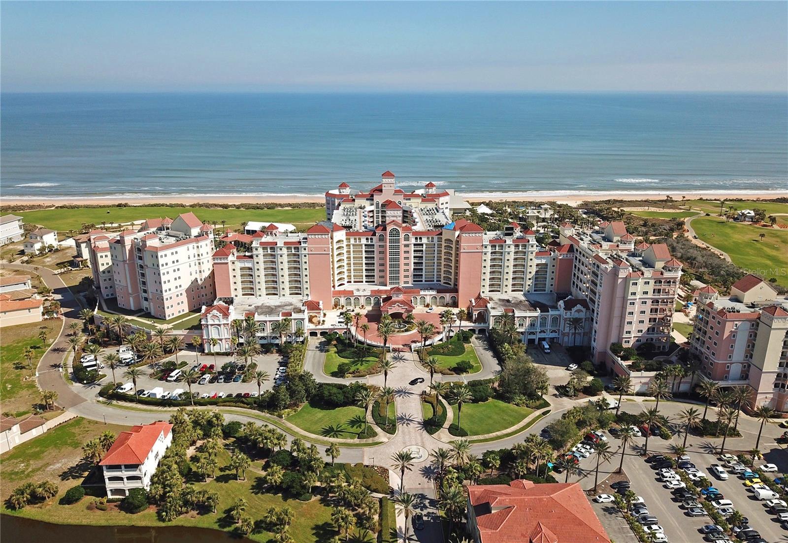 This exceptional renovated 8th-floor residence offers 4 bedrooms, 4.5 bathrooms, and 3,264 square feet in the highly sought after location in the main tower of the Hammock Beach Resort. Spectacular views overlooking the Atlantic Ocean and the 18th hole of the Jack Nicklaus- designed Ocean Course. A rare combination of size, views, and resort convenience, this home captures the essence of coastal luxury living. Designed for both comfort and entertaining, the expansive open-concept floor plan features polished travertine flooring, tray ceilings, crown molding, and walls of glass that fill the home with natural light while seamlessly connecting indoor and outdoor living. The gourmet kitchen is beautifully appointed with custom wood cabinetry, quartz countertops, premium appliances, a spacious center island, breakfast bar seating, wine refrigeration, and abundant storage. The spacious living and dining areas open seamlessly to an impressive 570-square-foot covered balcony, creating an ideal space to enjoy morning sunrises, ocean breezes, and panoramic views stretching across the coastline and golf course below. Electronic hurricane shutters provide convenience and peace of mind. The spacious primary suite serves as a private retreat with direct balcony access, stunning ocean views, and a beautifully updated spa-inspired bath featuring dual vanities, a walk-in shower and generous closet space. Each guest suite offers its own private bath, providing comfort and privacy for family and visitors. Additional highlights include six flat-screen TVs that convey with the property, a spacious laundry area, covered assigned parking, and a secure locked bike storage room. To further elevate the Hammock Beach lifestyle, a membership can be purchased so you can enjoy 5-star amenities. With two 18-hole Championship golf courses, nine pools including a lazy river, waterslides, eight Har-Tru tennis courts, pickleball courts, multiple dining venues, a world class spa, nine-hole mini golf course, volleyball court and a state- of-the-art exercise facility, you will always be enjoying Hammock Life!