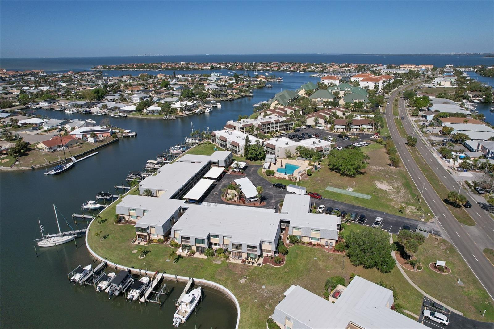 Truly a WOW property!  Nicely appointed 2 bedroom 2 bath with an abundance of living space including a sun room!  Dock with Electric lift boasting a weight capacity of 10,000 lbs. with lift runners that can be adjusted! Electrical power and water hose for easy boat cleaning and operation. Even Dolphins are known to come into the cove of Lake Sunrise!  This 55+ Community is the areas most desirable waterfront condo neighborhood. The interior features huge closets and spacious bedrooms!  Lovely flex space is ideal for entertaining and hobbies. This space leads on to a balcony allowing you to soak up the sun in comfort!  Upgraded kitchen is roomy and nicely appointed with sun room adjacent to it.  Plantation shutters abound!  You will enjoy a very neighborly community with plenty of activities with new friends! The pool is beautiful and great place to relax! Just a boat ride up the canal or a walk/bike ride are the areas best restaurants.  Enjoy a hike or relax at the areas Preserve!  Close to fantastic shopping and a stones throw to easy access roadways!  Welcome home!