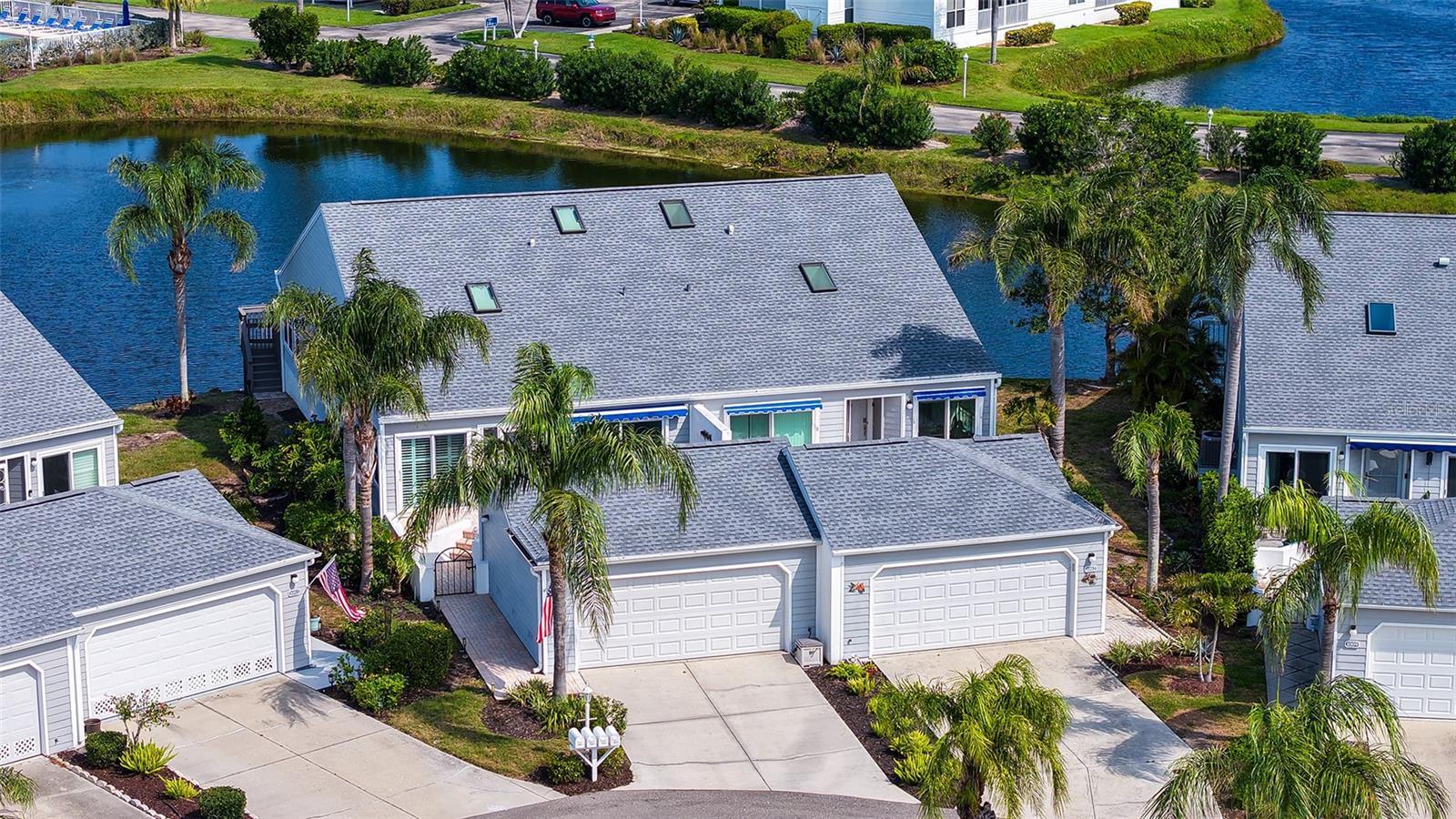Elegant Waterfront Villa in Perico Bay Club | 2 Bedrooms + Den | 2 Bathrooms
Experience the perfect blend of coastal elegance and carefree Florida living in this beautifully updated end-unit villa located in the highly desirable gated community of Perico Bay Club. Just minutes from the world-famous beaches of Anna Maria Island, this exceptional residence offers all the benefits of the Gulf Coast lifestyle — without the higher costs, traffic, and maintenance often associated with island properties.
Residents of Perico Bay Club enjoy a true resort-style lifestyle with beautifully landscaped grounds, community pools, fitness center, tennis & pickleball courts, kayaking, shuffleboard, scenic walking paths, and a fishing pier. Ideally located near Palma Sola Bay and directly across from Robinson Preserve, residents enjoy miles of hiking and biking trails, kayaking, and stunning coastal nature views.

This impeccably maintained Grand Cayman model features 2 bedrooms, 2 bathrooms, a den/optional third bedroom, and a spacious two-car garage, all thoughtfully designed to capture peaceful water views and natural light throughout. Large PGT impact windows, soaring ceilings, skylights, and multiple sliding glass doors create a bright, airy atmosphere that perfectly complements the relaxed coastal surroundings.
The sun-filled kitchen and breakfast nook are surrounded by large windows with plantation shutters and upgraded window treatments. Beautiful granite countertops, stainless-steel appliances, under-cabinet lighting, pantry storage, and elegant wood cabinetry with dovetail drawers that have both style and functionality.
The dining area flows seamlessly into the spacious family room, where 8-foot hurricane-rated sliding glass doors open to the enclosed Florida room and private Trex balcony overlooking the tranquil lake. Enjoy peaceful mornings and breathtaking sunsets surrounded by tropical birds, turtles, and serene waterfront views.
The spacious primary suite features a charming bay window, custom California Closets walk-in storage, and an updated bath with wide-plank tile flooring, dual vanities, and a beautifully designed walk-in tile shower with glass enclosure and bench seating.
Guests will appreciate the generously sized second bedroom with volume ceilings, sliding glass doors to a private front patio and a Hunter Douglas blackout shade for added comfort and privacy. The den, currently used as a sitting room, features double doors, high ceilings, a skylight, and a lighted ceiling fan, offering flexibility as a home office or optional third bedroom.

Additional updates include:
NEW ROOF – March 2023
HVAC – July 2017
HOT WATER HEATER – January 2022

Enjoy the beauty of Anna Maria Island just minutes away while returning home to the privacy, convenience, and peace of mind of gated waterfront living. 
Owner Financing May Be Available.
For More information on Perico Bay Club call for website link.