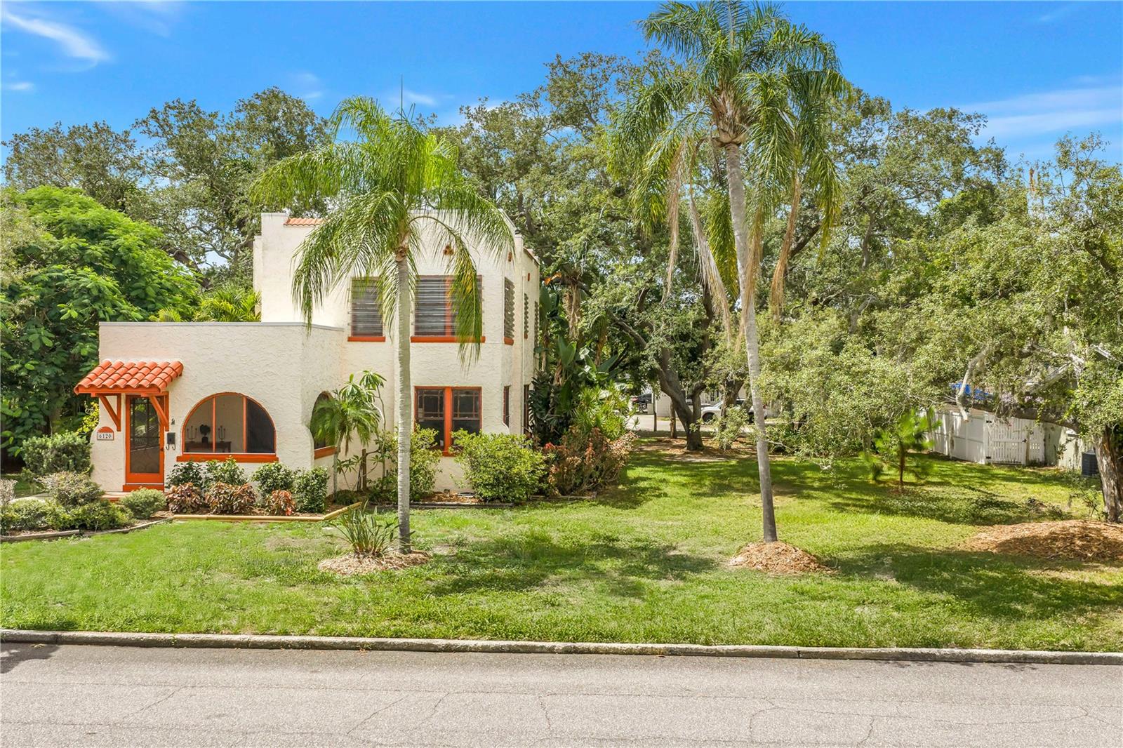 This beautiful Spanish Mediterranean, "La Casa Florida," has been lovingly owned by the same family since 1979. The light-filled home sits on 2.5 beautiful lots with lush, native landscaping, detached garage, and room to build your own outdoor oasis. "La Casa Florida" showcases beautiful period architecture and timeless details, including 10-foot ceilings, sash windows, stucco-over-hollow-tile construction, plaster walls, solid white oak floors throughout, Saltillo tile in the kitchen, and stained glass accents. Enter into a spacious screened-in porch, complete with Spanish tile and cool breezes. The double wood front doors invite you into a sprawling living room, anchored by the brick fireplace and gorgeous refinished hardwood floors. An archway leads you to the dining room, where the stained glass light mimics the foliage outside the windows. The kitchen features solid wood cabinetry, cooking peninsula, and lots of room to cook and gather. A laundry closet and full ADA-accessible bathroom complete the first floor. Upstairs, you will find three generously sized bedrooms, all with refinished hardwood floors. The Primary is full of morning sun, and has a dedicated sitting area for upstairs relaxation. The first guest bedroom features original wood paneling and custom wallpaper in the nook, perfect for a home office space. The second guest room features a small walk in closet and windows with tree-top views. Upstairs bathroom features a walk in shower and lots of storage. Major updates include a full electrical rewire, new roof in 2022, HVACs and ductwork updated between 2019-2026. Home sits high and dry out of any flood zones, and has complete opening protection, including hurricane shutters and a hurricane-rated door, that may provide a significant homeowners insurance discount. The spacious property offers a 2-car garage with electric service and potential for conversion to a casita, plus a shed, alley access, mature trees including live oaks, and two fruit-bearing avocado trees. A private well and irrigation system provide added convenience. Outdoor enthusiasts will love the easy walk or bike to the Pinellas Trail, two city parks, and close access to local favorites FreeFall Theatre, Practically Pikasso, Mercado, Dead Bob's, Crumb Factory, Craft Kafe and more. The beach and downtown are both less than 10 minutes away, with the SunRunner just 7 blocks from your front door. This is a rare opportunity to own a lovingly maintained home with exceptional character, generous land, and an unbeatable location close to schools, parks, dining, downtown, and the Gulf beaches.
