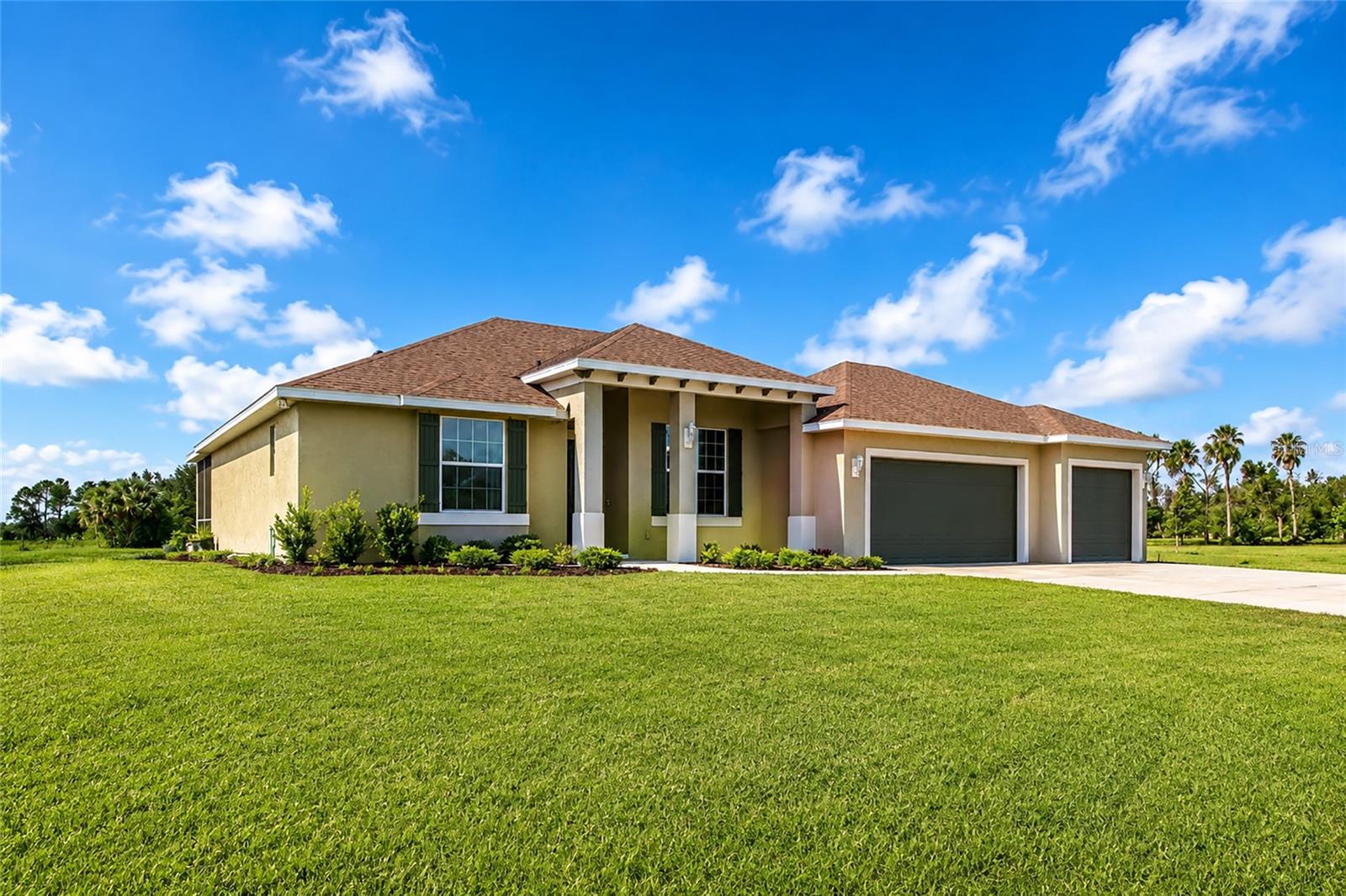 Rarely does a newer construction home become available in East County! Built in 2023, this exceptional 3 bedroom with walk in closets in all of them, 2 bath residence with a versatile bonus room, that could be a 4th bedroom and offers 2,407 square feet of thoughtfully designed living space on an incredible 5 acre homesite combining modern touches, energy efficiency and the FREEDOM you've been searching for! Step inside and immediately appreciate the soaring 9'4" ceilings, large windows and abundant natural light that create a bright, open and inviting atmosphere. The spacious open concept floor plan is ideal for both everyday living and entertaining, centered around an impressive chef's kitchen featuring a massive island, breakfast bar, generous cabinetry, and plenty of room to gather. Designed with quality and efficiency in mind, the home includes hurricane impact windows, spray foam roof insulation for enhanced energy savings, and countless modern features that make daily living comfortable year-round.
The oversized 3 car garage is a standout feature, complete with insulated garage doors and its own mini-split A/C system that's perfect for a workshop, home gym, hobbies, or protecting your vehicles and equipment from the Florida heat. Outside, you'll enjoy the peace of country living with the convenience of modern infrastructure, including a deep water well equipped with a premium, high-quality water filtration system. The expansive 5-acre property provides endless possibilities for outdoor living, recreation, gardening, or simply enjoying the privacy and open space. Best of all, there is NO HOA and NO DEED RESTRICTIONS, giving you the FREEDOM to truly make this property your own. Bring your horses, chickens, goats, and all your furry and feathered companions. There's plenty of room for boats, RVs, trailers, campers, ATVs, and other recreational vehicles without the limitations often found in neighboring communities. Located in highly sought after East County, where newer homes are becoming increasingly difficult to find, this property offers the perfect balance of peaceful country living while remaining 15-20 minutes to shopping, dining, recreation, and top rated schools. If you've been searching for a move in ready home with acreage, modern construction, exceptional energy efficiency, and unlimited possibilities, this one checks every box. CONTACTUS TODAY FOR YOUR SHOWING WHILE THIS NEWER BUILD IS STILL AVAIALABLE!