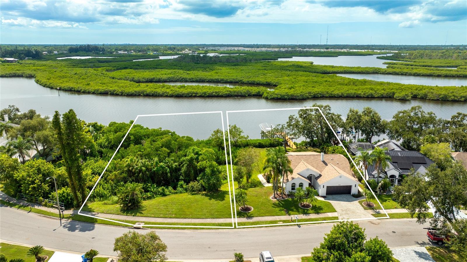Welcome to a rare two-for-one waterfront offering that doubles your opportunity along the Gulf Coast. This listing includes two separate parcels, each with its own address, deed, and buildable potential, sold together as a single package. The first, 4304, holds an updated three bedroom, two bathroom home with deep-water access that reaches the Gulf in just 25 minutes. The second, 4308, is a buildable waterfront lot ready for a future custom home, an investment build, or the privacy of owning the land next door. Live in the existing home and build, hold the second parcel as an appreciating asset, or create a true family compound on the water. Set along a wide, navigable channel with preserve views across the water, the property delivers the privacy and serenity that define the Gulf Coast lifestyle. Mornings bring dolphins and manatees past your backyard, afternoons invite casting for snook and redfish off your dock, and evenings close with sunsets glowing over the mangroves. Built for life on the water, the property features a fully updated dock with water, electric, and a lift, backed by a durable riprap seawall. The wide channel allows full wake boating straight from your backyard, while the combined acreage lends a rare sense of space seldom found along navigable water. Inside, modern updates meet panoramic water views. Soaring ceilings, clerestory windows, and walls of glass fill the great room with natural light while framing the waterfront beyond. A sleek fireplace anchors the open layout, which flows into the dining area, screened porch, and outdoor deck for easy entertaining after a day on the boat. The kitchen is bright and welcoming, with granite counters, updated appliances, and a breakfast bar open to the living space. The primary suite is a private retreat with sliding doors to the yard, sweeping water views, and a remodeled bath featuring dual sinks and a walk-in shower. Two additional bedrooms offer flexibility for guests, an office, or a den, and the second bath has been refreshed with clean, contemporary finishes. Recent improvements include updated lighting and fixtures, a leveled yard, and enhanced exterior railings and decking. From the green lawn rolling to the water's edge to the screened lanai where the sun slips below the horizon, this is waterfront living without compromise. With direct Gulf access, a refreshed interior, and two separate waterfront parcels conveying together, this is one of the most distinctive opportunities in Bradenton today. Come experience the rare blend of space, privacy, and possibility for yourself. **THIS PROPERTY QUALIFIES FOR A 1% LENDER INCENTIVE IF USING PREFERRED LENDER. INQUIRE FOR MORE DETAILS.**