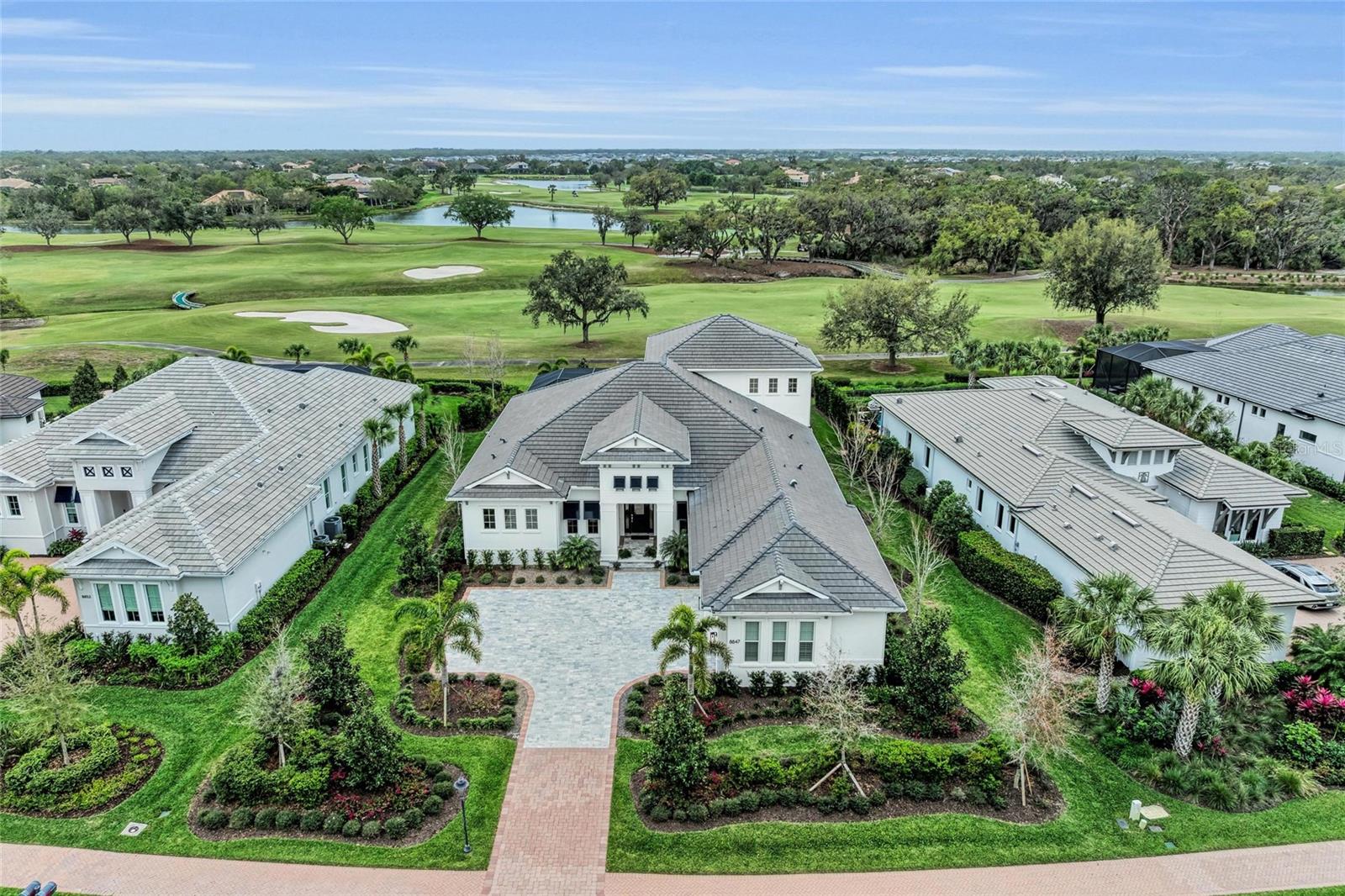 Come home to this magnificent custom coastal contemporary Lee Wetherington residence with sweeping golf course views. Tucked behind the gates of the Founders Club, a stunning neighborhood of only 262 homes nestled amidst nature and one of the region's best golf courses. Built on a premium golf-view site with easy access to the clubhouse, this home offers an idyllic setting and lifestyle. A quiet, tree-lined street leads to a picturesque home that must be experienced to be fully appreciated. Set against the serene backdrop of a rolling fairway studded with ancient oaks and across from a protected preserve, this home provides privacy and tranquility. Inside, glorious soft natural sunlight, a cheerful ambiance, and lovely views are experienced throughout. Tall ceilings are emphasized with beautiful trim detail, and the grand great room flows effortlessly through the 10’ sliding glass doors to the stunning outdoor living. With over 4,000 square feet of air-conditioned space, you’ll have plenty of room for gathering and privacy. In addition to the 4 bedrooms, you'll find a study, a bonus room, and a loft. The outdoor oasis offers more incredible space with a saltwater heated pool and spa, outdoor kitchen, and panoramic screen. 

The designer kitchen features quality wood cabinetry with soft close doors, a hidden pantry, Thermador appliances including a natural gas range, furniture-wrapped column refrigerator and freezer, double ovens, a tall wine cooler, and gleaming Cambria quartz countertops. Beautiful designer touches include European white oak floors in main living areas and primary bedroom, a lovely Dimplex 72” linear fireplace built in, classic trim and millwork details, elegant lighting, plantation shutters, remote blinds, and Sonos sound system. The well-appointed owner’s retreat features a spa-inspired bath with floating tub, frameless shower, built-in coffee bar, and double walk-in closets. This green-energy-certified home is quality built and offers peace of mind from the storms. Impact windows and doors. Landscape lighting and lush professional landscaping enhance the home in the day and evening. 

Optional social and golf memberships. Clubhouse offers gourmet restaurant with fine and casual dining, 24-hour fitness center, social activities, and holiday events. An on-site fitness center offers Pilates and yoga classes, and Har Tru tennis courts are available for residents. Founders Club is 9 miles from downtown Sarasota with easy access to cultural venues and world-class beaches. Enjoy the best of Sarasota living with convenience to various grocers, medical facilities, farmers markets, shops, polo fields, and many restaurants. This immaculate home is ideal for those who desire new construction without the wait!