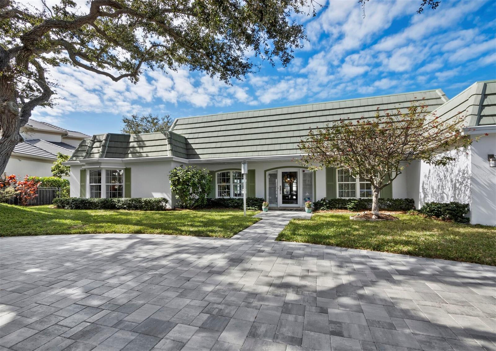 This canal-front home on Bird Key offers direct boating access with no bridges to Sarasota Bay or the Gulf. Located one lot in from the corner, the residence includes 3 bedrooms, 3.5 baths and approximately 2,970 square feet of living space and 136 linear feet of water frontage just off the open bay. A circular paver driveway and mature landscaping create an inviting entrance. Inside, large tile floors run through the main living areas, and French doors provide abundant natural light while opening directly to the pool and screened lanai. The kitchen features black stone countertops, white cabinetry with glass accents, stainless steel appliances and a black-and-white tile backsplash. An adjacent dining area connects easily to both the kitchen and living spaces. The split-bedroom layout offers privacy and flexibility. Two bedrooms have en-suite baths and direct pool access, making them ideal for guests. One suite includes French doors to the pool and an updated bath with built-in shelving and a glass-enclosed corner shower. The primary suite also opens to the pool and includes wood flooring, a custom walk-in closet, dual vanities, a soaking tub and a separate walk-in shower. The screened lanai surrounds a large pool and provides covered seating areas for outdoor living. A private dock sits on a quiet canal with quick access to Sarasota Bay, making it easy to get out on the water. Living on Bird Key means more than just waterfront access. The neighborhood is known for its private, residential setting with wide streets and a strong sense of community. Residents enjoy proximity to downtown Sarasota, Lido Beach and St. Armands Circle, all just minutes away. Homeowners also have the option to join the Bird Key Yacht Club, which is currently being rebuilt from the ground up. The new club will offer updated dining, social spaces, fitness facilities and marina amenities, further enhancing the boating and social lifestyle that defines the island.