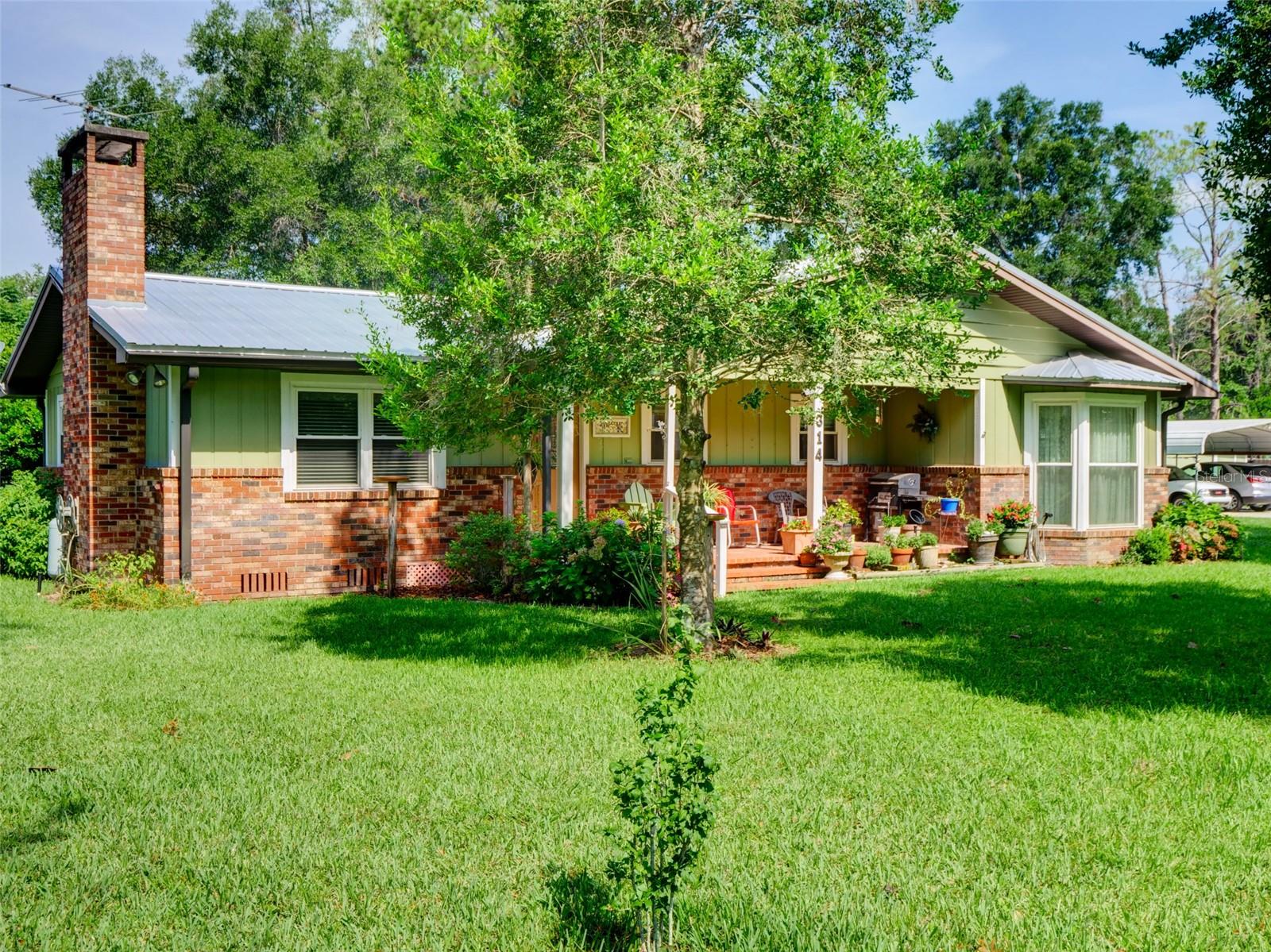 Welcome home to this beautifully maintained 3-bedroom, 2-bath home nestled in the heart of Bushnell! Situated on 0.75 acres, this property offers the perfect blend of space, comfort, and convenience.From the moment you arrive, you’ll appreciate the beautiful mature oak trees that provide shade and create the perfect setting to relax on the porch with your morning coffee or unwind in the evening.Inside, you’ll find a cozy fireplace that can be enjoyed as either wood-burning or gas. The kitchen has been thoughtfully updated with a new built-in oven and microwave combination and a new refrigerator, making it both stylish and functional.This home has been exceptionally well cared for with numerous updates, including a new A/C installed in 2025, a new water heater (2025), a metal roof approximately 10–11 years old, and new South Windows with a lifetime warranty.Outside, you’ll love the added conveniences this property offers. Although the home is on city water, it also has its own 4-inch well, making it easy to water the lawn, wash your vehicles, or tackle outdoor projects while helping reduce water costs. The irrigation system is equipped with timers, making lawn maintenance a breeze.The property also features a workshop with electricity and a concrete slab floor, providing the perfect space for projects, hobbies, or extra storage. A lean-to carport offers covered parking for your vehicles, boat, or outdoor equipment. The spacious 0.75-acre lot also provides the opportunity to add a guest house or in-law suite, subject to county approval.Conveniently located just minutes from I-75, you’ll enjoy quick access to Ocala, Tampa, and Orlando, with both Tampa International and Orlando International Airports approximately one hour away.You simply can’t beat everything this home has to offer! Whether you’re looking for your first home, a place to retire, or extra room to grow, this property is ready to welcome you home. Don’t miss your opportunity to own a beautiful piece of Sumter County in the charming town of Bushnell. Schedule your private showing today!