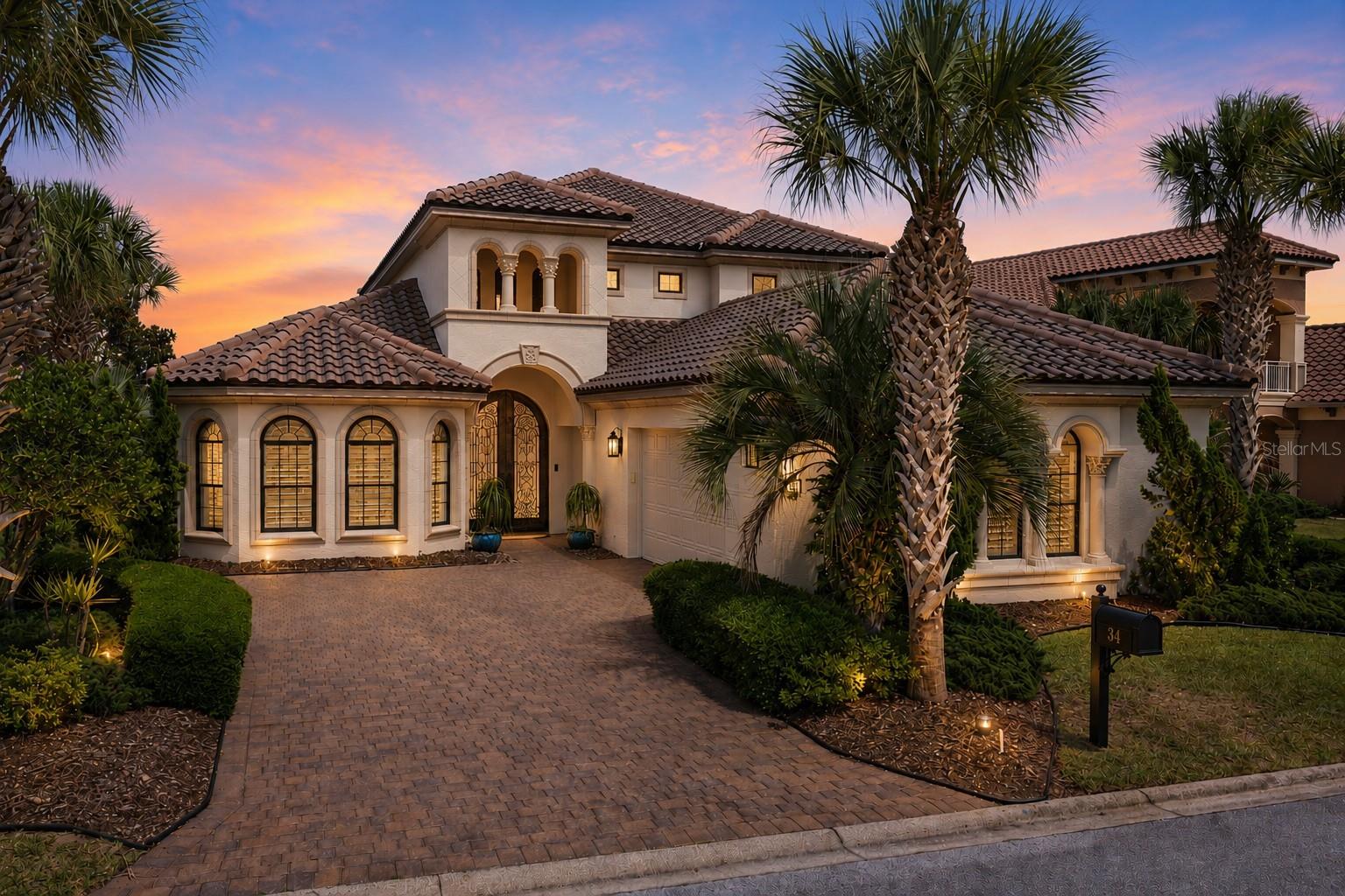 Welcome to an extraordinary Arthur Rutenberg luxury residence on coveted Kingfisher Lane within the exclusive gated community of Ocean Hammock — a vibrant and welcoming street known for its friendly neighbors, festive block parties, and strong sense of community. Perfectly positioned on a serene lakefront homesite overlooking the golf course and just moments from the Atlantic Ocean, this impeccably designed home offers a rare blend of elegance, comfort, practicality, and coastal sophistication. 

From the moment you arrive, the striking Mediterranean-inspired architecture, paver driveway, and stunning custom cast-iron double entry doors create a breathtaking first impression. The entire exterior of the home was just freshly repainted, giving the property a crisp, refreshed curb appeal and a move-in-ready feel from the moment you arrive. Inside, soaring ceilings, rich wood flooring, dramatic cast-iron staircase detailing, coffered ceilings, and abundant natural light elevate every space with timeless luxury and architectural character.

Thoughtfully designed for both everyday living and effortless entertaining, the expansive floor plan offers exceptional functionality alongside refined aesthetics. The first-floor primary suite provides a peaceful private retreat, while the conveniently located first-floor study with double doors creates the perfect home office, library, or flex space just off the main living area.

The grand great room flows seamlessly into the gourmet kitchen, beautifully appointed with custom cabinetry, granite countertops, premium stainless-steel appliances, an oversized breakfast bar, and center island designed for gathering with family and guests. Extensive storage throughout the home — including large storage closets and cleverly utilized attic space within the roof trellis design — reflects the careful attention given not only to beauty, but to livability and practicality.

Upstairs, the home is perfectly designed for hosting family and guests with spacious guest suites featuring ensuite bathrooms, a versatile loft living area, and a private screened balcony capturing gorgeous lake and golf course views along with refreshing ocean breezes drifting in from the nearby Atlantic.

The primary suite is a luxurious sanctuary of its own, featuring warm wood flooring, elegant tray ceilings with natural textures, abundant natural light, and a serene sitting area perfect for morning coffee or quiet evenings. The spa-inspired primary bath offers dual vanities, granite countertops, a soaking tub, walk-in shower, and an atmosphere designed for relaxation and retreat.

Step outside to the spectacular screened lanai where the true magic of coastal living unfolds. Enjoy peaceful evenings soaking in the spa while listening to the distant sound of the Atlantic Ocean, feeling cool ocean breezes, and watching the sky transform with breathtaking sunset colors before the moon rises over the lake. The tranquil golf and lagoon setting attracts an abundance of natural wildlife, creating a constantly changing backdrop of tropical birds, turtles, and even playful otters gliding through the water.

This exceptional Kingfisher Lane residence offers the ultimate combination of luxury, warmth, functionality, and lifestyle within one of Palm Coast’s most sought-after coastal communities.