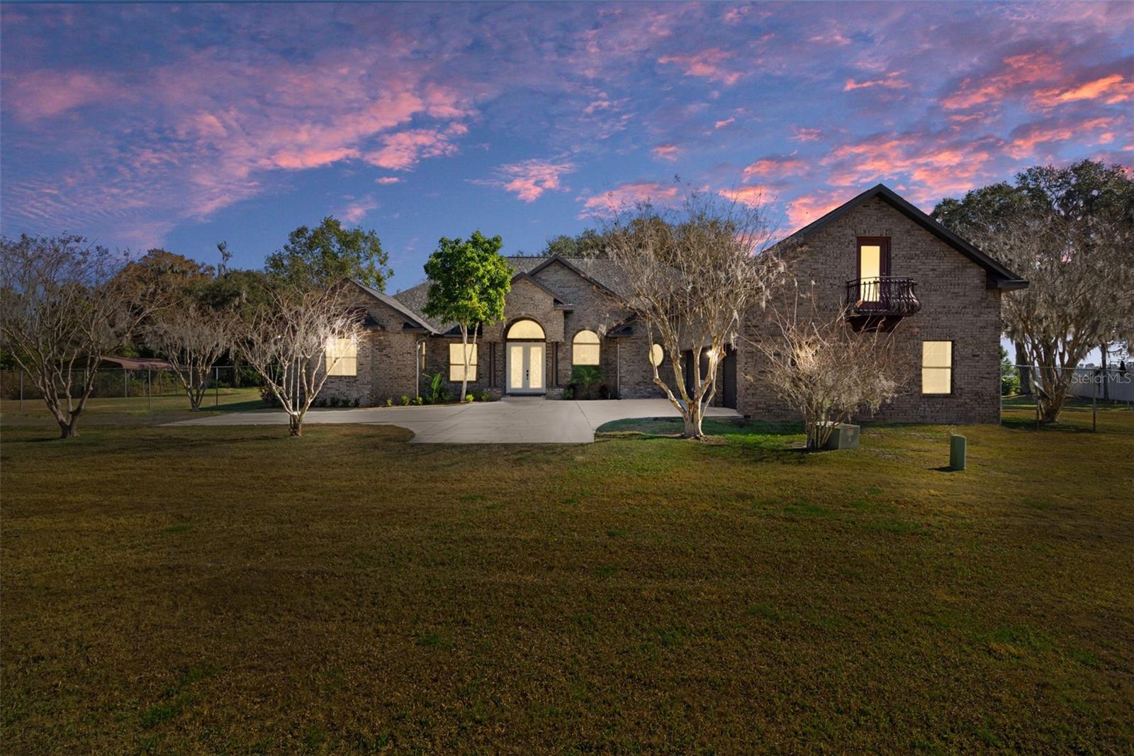 New to market! This prime Lake Wales lakefront estate on the shores of 3,855-acre Lake Pierce is a slice of old Florida that doesn’t come around often. The property features a 2009 custom-built 5-bed / 4-bath / 3-car garage / 3,139 SF pool home on an expansive 4.3 acres with over 275' of freshly groomed lakefront and a 75’ dock with two covered boat lifts. Every bit as grand as it looks, the home’s solid brick-faced concrete block exterior walls provide as much substance and security as beauty. Stepping through the double front doors into the foyer, you’re immediately captivated by the living room’s panoramic views of the lake through a bank of windows and French doors that open to the lanai. The striking entrance and ten-foot ceilings throughout give the split-ranch floor plan a breathtaking open feel. The living and dining rooms seamlessly transition into the family room and kitchen with ample granite countertops, hardwood cabinetry, walk-in pantry, prep island, new LED lighting, exterior ventilation, and stainless appliances, including a NEW REFRIGERATOR, DISHWASHER, and MICROWAVE. A custom-built dining nook adjoins the family room with wood-burning fireplace where banks of double-pane windows and French doors reveal sweeping views of the lakefront. The doors open to a screened pool and covered lanai—a perfect backdrop for entertaining, or your morning coffee. Past the kitchen are two spacious bedrooms connected by a full Jack-and-Jill bath, a hallway leading to the laundry room, upstairs bonus suite, and 3-car garage. The upstairs suite is a multi-purpose space that can serve as a bedroom, office, game room, gym, etc. It has an en-suite full bath, dedicated A/C, walk-in closet, and door to a small balcony. The other side of this split-plan features the primary suite, including a large bedroom, dual walk-in closets, and bathroom with dual sinks, granite countertops, hardwood cabinetry, garden hydro-tub, separate shower with steam feature, and water closet with toilet and bidet. French doors lead out to the lanai, offering the same lake view. Outside the primary entrance is an additional bedroom and full hall bath accessible from the lanai. This exceptional house can only be rivaled by its spectacular outdoor surroundings, easily accessed from the living and family rooms, primary suite, and hall bath. Much care was taken to preserve the natural Florida landscape and wildlife habitats and still provide open views and clear lake access. Stroll the lake bank, teeming with wildlife, and enjoy the newly exposed natural cypress-tree garden cove. Walk out on the dock for unobstructed lake views, fishing, or launching a watercraft from one of the two covered boat lifts, that have NEW LIFT MOTORS, DRIVE BELTS AND CABLES - each rated up to 4,500 lbs. General PROPERTY UPDATES IN 2025 include: FULL ROOF REPLACEMENT, completely REPAINTED INTERIOR, all NEW LED LIGHTING FIXTURES inside and outside, NEW BEDS, MULCH AND LANDSCAPING, REPAINTED POOL AND PATIO DECK, NEW WELL PUMP and IRRIGATION SYSTEM, 2 NEW HOT WATER HEATERS, and NEW CARPET in all bedrooms. Utilities are underground, and the property is equipped with a whole-house Generac generator. This paradise is secluded yet in near proximity to 3 of the largest cities along the central Florida corridor (66 mi E of Tampa, 52 mi SW of Orlando, and 29 mi E of Lakeland), only 6 miles from AdventHealth hospital, and 10 minutes to Publix, Home Depot, Walgreens, and other retail conveniences.