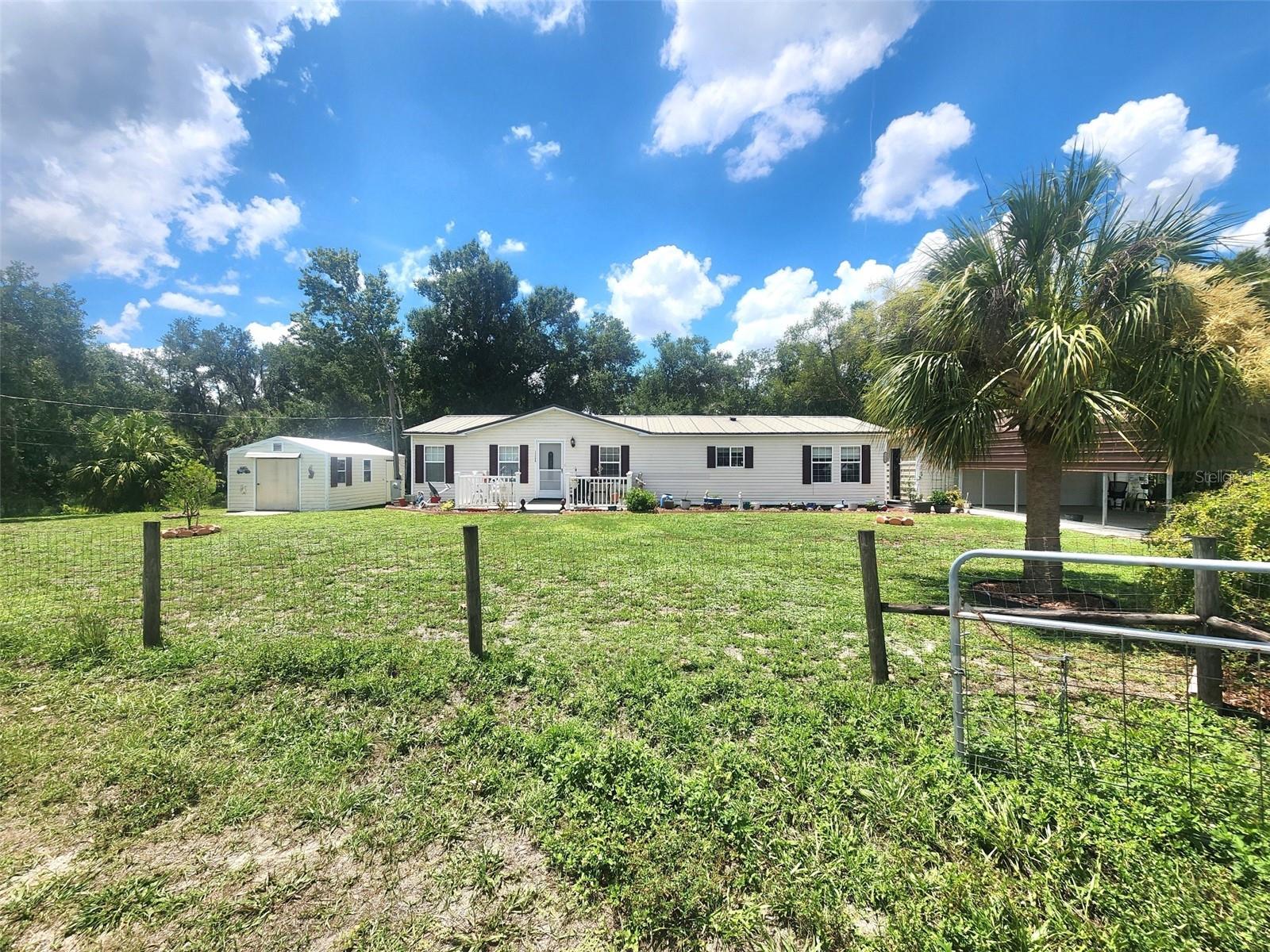Nestled on a peaceful homesite in desirable Southwest Arcadia, this beautifully maintained **2-bedroom, 2-bath home with a spacious den currently utilized as a third bedroom** offers the perfect blend of country living and modern comfort. The versatile den features a **built-in Murphy bed and desk that will convey**, making it an ideal guest room, home office, or flex space.

Step inside to discover a thoughtfully designed floor plan featuring a **formal dining room**, generously sized bedrooms, oversized closets, an inside laundry room, and numerous recent updates throughout. Enjoy **new flooring, updated toilets, and new kitchen appliances**, creating a move-in-ready home you'll love from day one.

Outside, you'll find exceptional space for all your vehicles, hobbies, and storage needs with a **new metal roof (2023)**, an oversized **2.5-car garage**, attached carport, and **multiple storage sheds**. The backyard is truly a hidden gem, where a charming owner-built bridge leads to a peaceful setting to relax, enjoy nature, fish, or simply take in the beauty of Old Florida.

Located just minutes from historic downtown Arcadia, you'll enjoy easy access to locally owned shops, antique stores, restaurants, and community events. Outdoor enthusiasts will appreciate being close to the scenic **Peace River**, known for kayaking, canoeing, boating, fishing, and world-famous fossil and shark tooth hunting. Popular local destinations including the **Nav-A-Gator Bar & Grill** at the Peace River Marina offer waterfront dining, live music, airboat tours, kayak rentals, and boating adventures, while downtown favorites like The Yellow Deli and Slim's Bar-B-Q are just a short drive away. Nature lovers will also enjoy nearby hiking, horseback riding, and wildlife viewing at the area's preserves along the Peace River corridor.

If you've been searching for a home that offers updated living spaces, abundant storage, room to spread out, and the peaceful charm of country living with convenient access to recreation and downtown amenities, this property is one you won't want to miss!