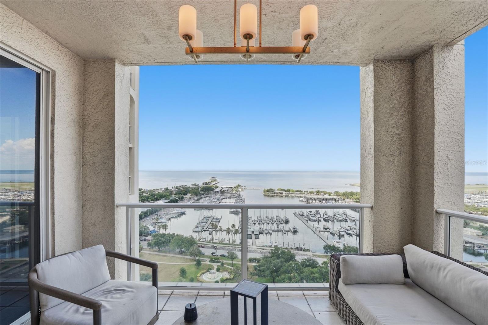 Experience luxury penthouse living on prestigious Beach Drive in the heart of downtown St. Petersburg. Penthouse 1900 at Florencia is an extraordinary two-story waterfront residence occupying the 19th and 20th floors of one of the city's most exclusive boutique condominium buildings. Offering nearly 5,000 square feet of sophisticated living space, four deeded under-building parking spaces, and panoramic views of Tampa Bay, the St. Petersburg Marina, Straub Park, Albert Whitted Airport, and the vibrant downtown skyline, this residence delivers an exceptional combination of elegance, privacy, and an unmatched downtown lifestyle. Walls of curved floor-to-ceiling glass showcase impressive water and city views throughout the home, while four private terraces provide the perfect setting to enjoy quiet sunrises over Tampa Bay, sparkling evening skylines, and year-round waterfront living. Thoughtfully designed with timeless architecture and refined contemporary finishes, the residence features rich herringbone hardwood flooring, sculptural glass staircases, custom architectural millwork, designer lighting, and beautifully curated living spaces that are equally suited for elegant entertaining and everyday comfort.  The flexible floor plan offers four spacious bedroom suites, each with a private en-suite bath and walk-in closet. The luxurious primary suite, features a spacious sitting lounge, morning bar, dual spa-inspired bathrooms, expansive custom dressing rooms, and magnificent waterfront views from nearly every room. Florencia is one of downtown St. Petersburg's premier boutique luxury condominium residences, offering an intimate atmosphere with exceptional privacy, personalized concierge service, a resort-style waterfront pool and spa, state-of-the-art fitness center, elegant social rooms, guest suites, and secured access. An exceptional offering, the residence includes four deeded parking spaces—a highly desirable feature rarely found in downtown condominium living. From your building front door, enjoy the very best of Beach Drive, with waterfront parks, the St. Petersburg Pier, world-class museums, fine dining, sidewalk cafés, marinas, boutiques, and the city's thriving arts and cultural district just moments away. Call for your preview appointment today!