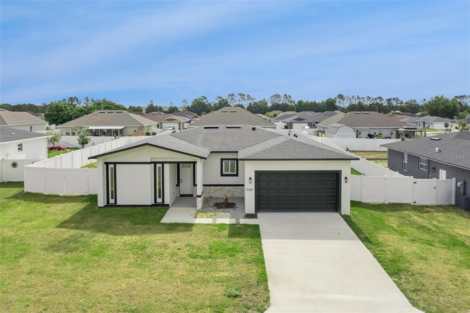 Welcome to this beautifully crafted new construction home located at 10281 SE 67th Terr, Belleview, FL 34420, offering the perfect blend of modern design, functionality, and comfort. Situated on just over a quarter-acre lot with no HOA, this 4-bedroom, 3-bathroom residence provides the space and freedom you’ve been looking for—along with the peace of mind that comes with a brand-new, full block reinforced build.

Boasting 1,931 sq ft of living area and 2,625 total sq ft under roof, this home features an open-concept floor plan enhanced by high ceilings, creating a bright and airy atmosphere throughout. The interior is finished with stunning rectified porcelain tile (24x48) and laminate flooring, delivering both luxury and durability.

The heart of the home is the beautifully designed kitchen, complete with stone countertops, stainless steel appliances, stylish pendant lighting, and modern cabinetry accented with all shaker-style doors throughout the home. Perfect for entertaining or everyday living.

The thoughtfully designed split-bedroom floor plan ensures privacy for all. The spacious primary suite is a true retreat, featuring elegant tray ceilings, a walk-in closet, and a well-appointed ensuite bathroom with a stand-alone shower. On the opposite side of the home, you’ll find two additional bedrooms and a full bathroom with a tub/shower combination, ideal for family or guests.

Tucked away at the back of the home is the fourth bedroom, offering added privacy and direct access to a full bathroom with a stand-alone shower—perfect for visitors or a private guest suite.

Enjoy indoor-outdoor living with large sliding glass doors that open to a covered lanai, overlooking a spacious fully fenced backyard with vinyl privacy fencing—ideal for relaxing, entertaining, or pets.

Additional highlights include central air conditioning and heating, an inside laundry room, and a 2-car garage featuring an upgraded 8-foot garage door (a premium upgrade over the standard 7-foot), offering extra clearance for larger vehicles.

This home combines quality construction, thoughtful upgrades, and modern style—all in a convenient Belleview location. Don’t miss your opportunity to make it yours!.
