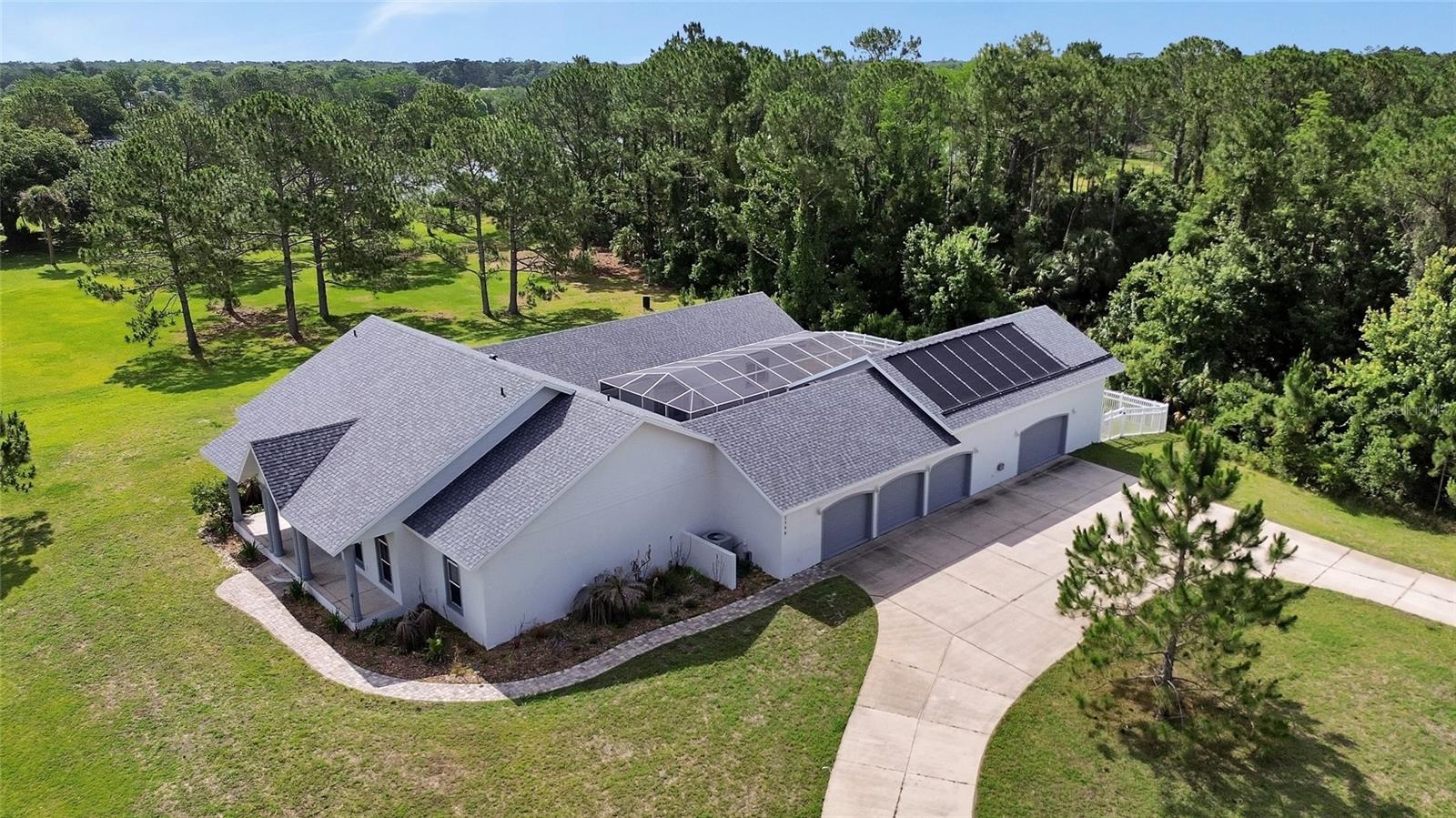 Virtually Staged. This estate property offers a rare combination of some of today’s most sought-after features; Set on over 2 acres in New Smyrna Beach. Designed for both entertaining and everyday living, the home features a chef’s kitchen that connects to expansive gathering spaces ideal for hosting family and friends. A private multi-generational suite adds flexibility for extended family, guests, or private living arrangements.
The pool courtyard creates a relaxing retreat complete with a spa, outdoor shower, and fenced dog run. Car enthusiasts, hobbyists, or those needing additional storage will appreciate the oversized 3-car garage and separate air-conditioned workshop space, with a 30-foot attic storage area with lift access directly from the garage.
Among many notable features, this home has no history of flooding. Additional upgrades and features include waterproof luxury vinyl plank flooring throughout the main living areas installed in 2023, a whole-home generator connected to a 500-gallon propane tank (owned), continuous-use gas water heater with a circulation system, temperature-controlled storage room, a 2024 roof and a solar pool heater installed in 2023. 
Conveniently located close to shopping, dining, and everything New Smyrna Beach has, this unique property combines acreage living with the functionality and features buyers are searching for today.
All information including measurements are intended to be accurate, but not guaranteed. Interested parties must verify all important information. Some photos have been virtually staged.