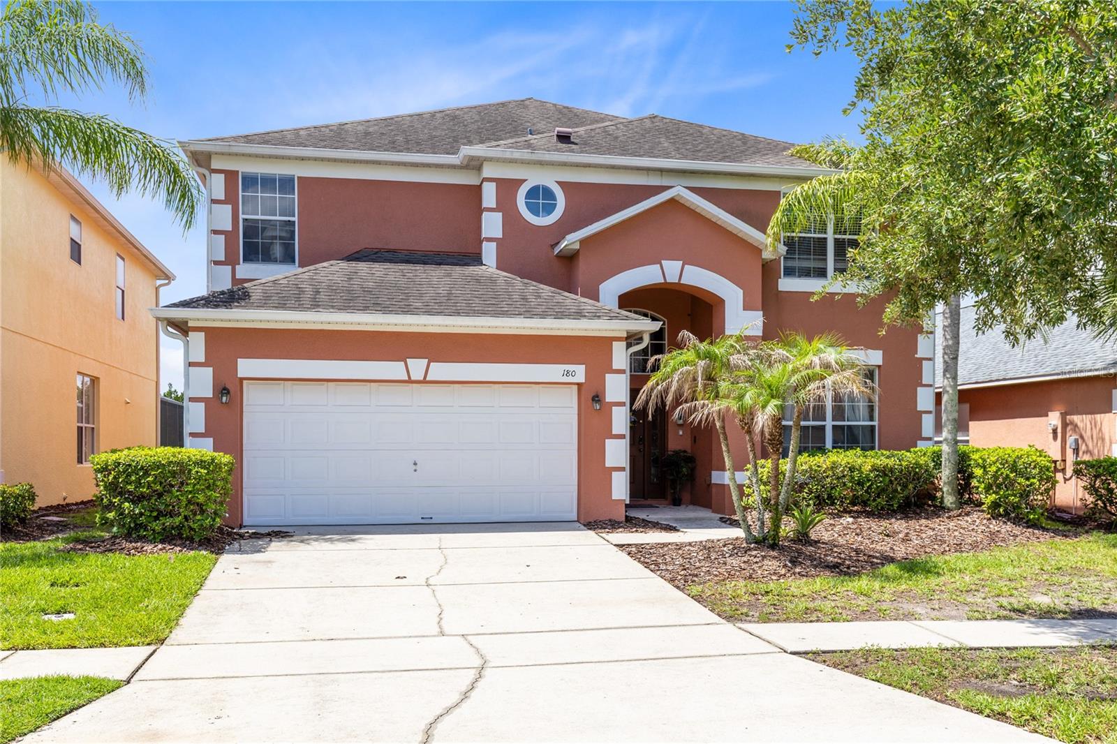 Welcome to Terra Verde, a gated resort-style community in the heart of Kissimmee. This 7-bedroom, 4.5-bath home offers 3,020 heated square feet, a flexible two-story layout, and a private screen-enclosed pool area made for relaxed Florida living. The main level opens to bright tile living spaces with a front living room, separate dining area with arched built-ins, and an open family room that connects naturally to the kitchen and breakfast area. The kitchen features blue cabinetry, stainless steel appliances, a closet pantry, and direct sightlines to the family room and pool deck. Sliding glass doors lead to the covered lanai and wide screened pool deck, where the in-ground pool, deck lighting, lounge space, and tall privacy hedges create an easy indoor-outdoor setting for entertaining or unwinding. The first-floor primary suite offers privacy, a walk-in closet, and a bath with dual sinks, soaking tub, and separate shower. Upstairs, a spacious wood-floor loft anchors six additional bedrooms and three full baths, giving everyone room to spread out. A converted garage/game room adds another casual hangout zone. Terra Verde offers guard-gated entry, clubhouse, resort-style pool, tiki bar, fitness center, arcade, playground, basketball, volleyball, shuffleboard, sidewalks, and fishing. A strong fit for a primary residence, second home, or Central Florida getaway close to area attractions.