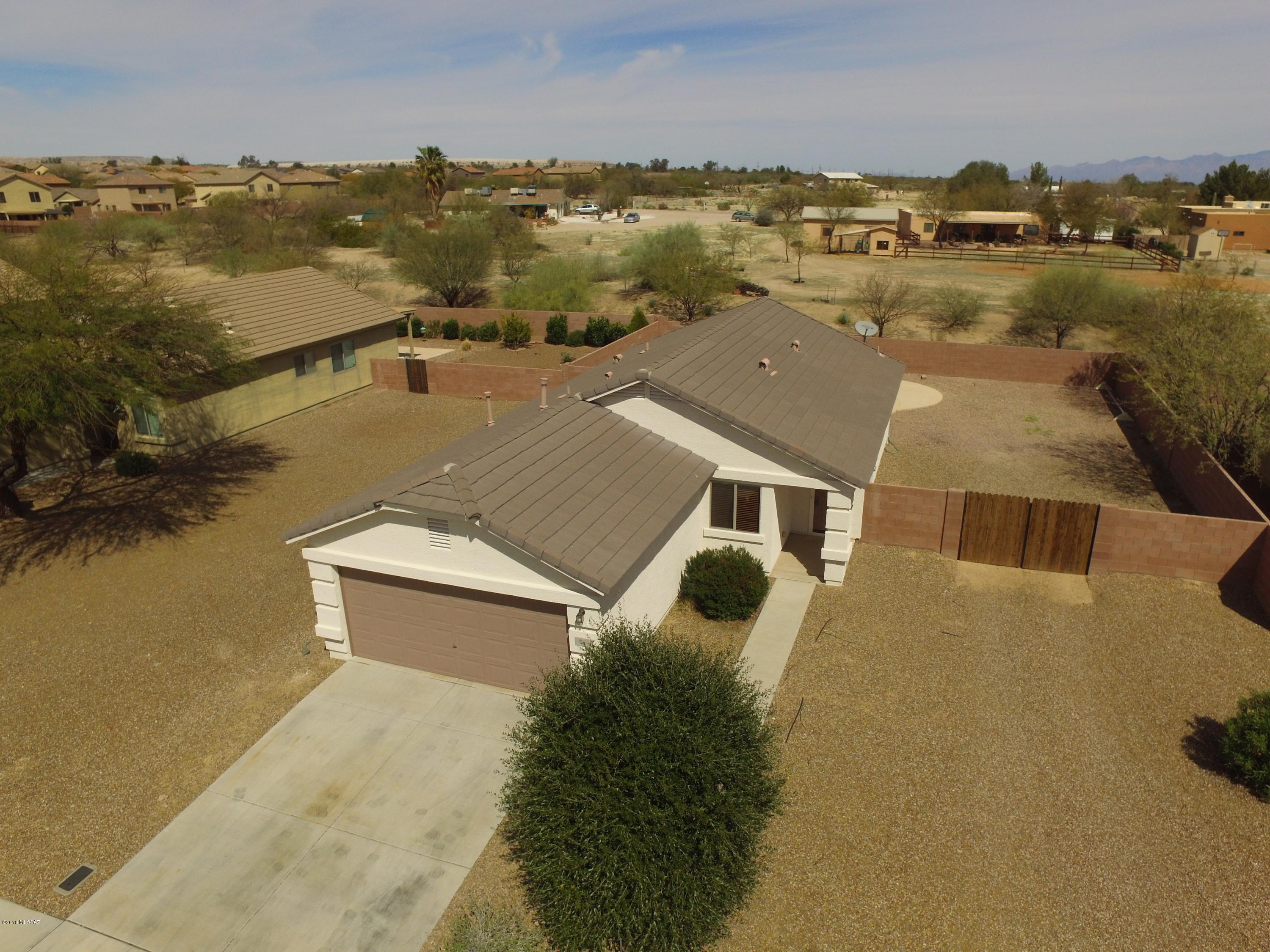 Welcome to this nicely maintained family home in Los Arroyos. This home is situated on a double lot, with 10' gate, backing to an Arroyo so there are no rear neighbors. The 1094 SF home with 3 bedrooms and 2 baths is the perfect size for retirees or young families. The interior has been freshly painted, maple cabinets with lower pull-outs in kitchen, and tasteful tile flooring through out the living areas and hall. Clean and move-in ready for you. Nearby you'll find convenient access to shopping, dining, and easy access to the Interstate. Add to that, a sparkling back yard pool, plenty of parking for all of your toys, and a yard just waiting for your personal touches. This one is definitely one you'll want to put on your list if you are looking for a Green Valley address without the GVR.