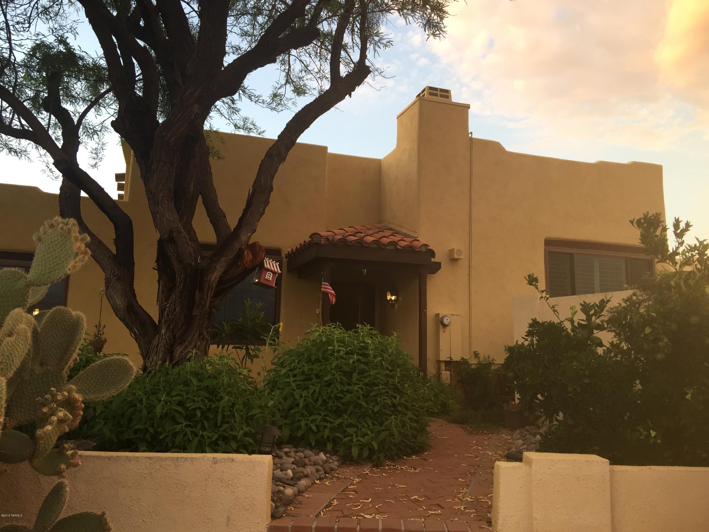 You know this house is going to be charming the minute you walk up the meandering, tree lined sidewalk. Positioned on a corner lot, there are great views of the Catalina Mountains. Inside, warm saltillo tile, clerestory windows, cathedral wood lined ceilings & gas fireplace are simply sublime! Ck out the lights! The kitchen is impossibly gorgeous with built in GE appliances,gas cooktop,hood,& a most unique designer touch on the Thomasville cabinets.. hand painted panels on some upper cabinets, along with open shelving! Granite countertops are just the frosting on the cake!  Bathrooms are completely remodeled.. fabulous cabinetry & copper sinks.  Oh did we mention the windows are all new as is the solar hot H2O system?  Pebble tech pool & wrap around patio are fab!  Say YES to this Address!