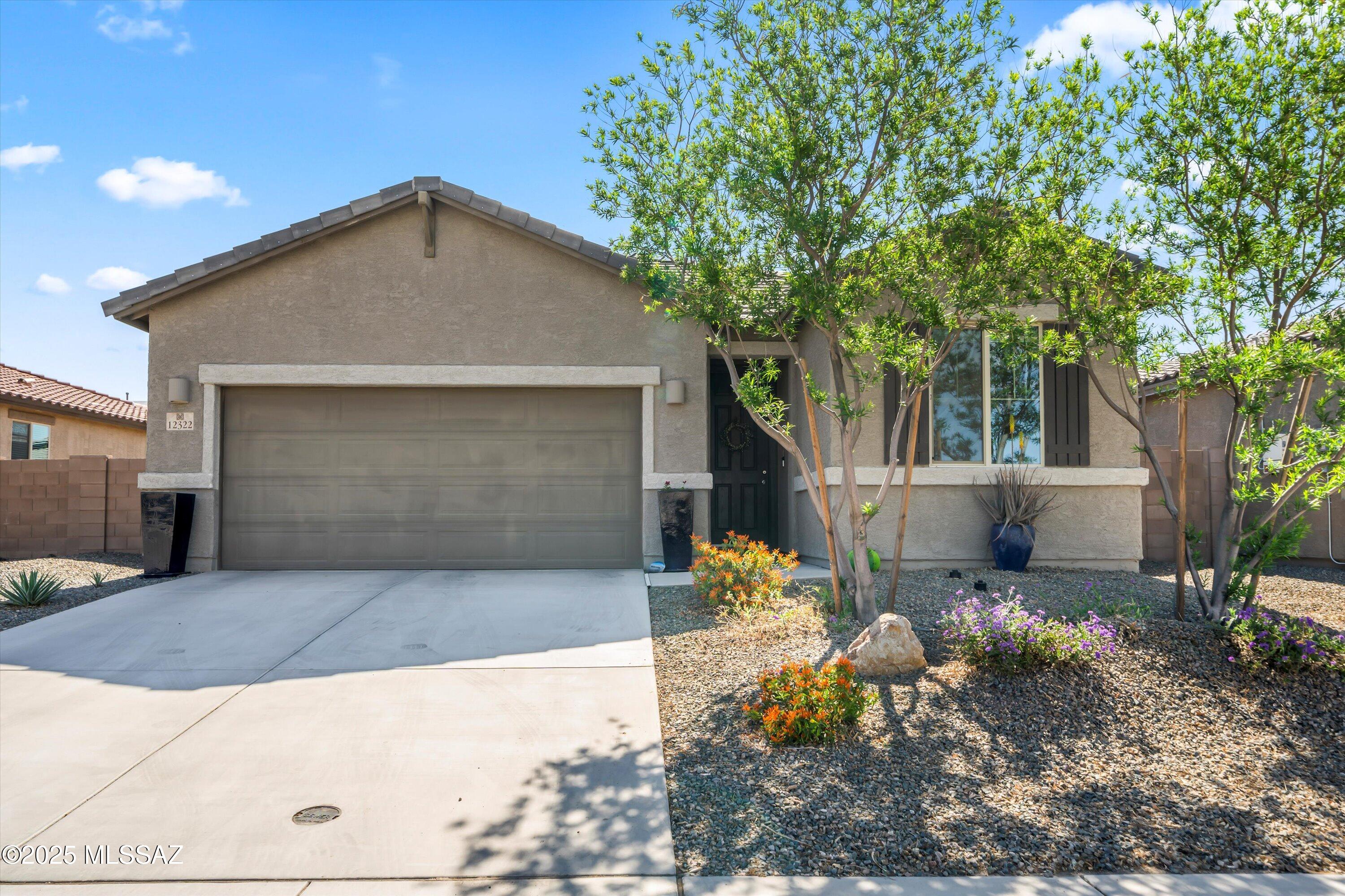 Welcome home to this newer home in the amazing community of Gladden Farms. The home is close to parks, dog park, splash pad, the new Marana Aquatic and Rec Center, new grocery store, new schools, and a future businesses. At the center of the home is the modern kitchen with black cabinets, white quartz counters, tile backsplash, vent hood, and an island with seating and pendant lights. Off the kitchen is the living room featuring can lights, ceiling fan, and a massive center meet sliding glass door leading to the backyard. The backyard is complete with covered patio, pavers, artificial grass and beautiful plants. Heading back inside, you will find a small, but convenient office nook outside the master bedroom. The master bedroom features ceiling fan, can lights, extra windows, and farm door leading to the en-suite bathroom that offers dual sinks, quartz counters, framed mirrors, upgraded lighting, linen closet and walk in closet. The split floor plan offers two secondary bedrooms, away from the master, both with ceiling fans and can lights.  The home also features a 2.5 car tandem garage.