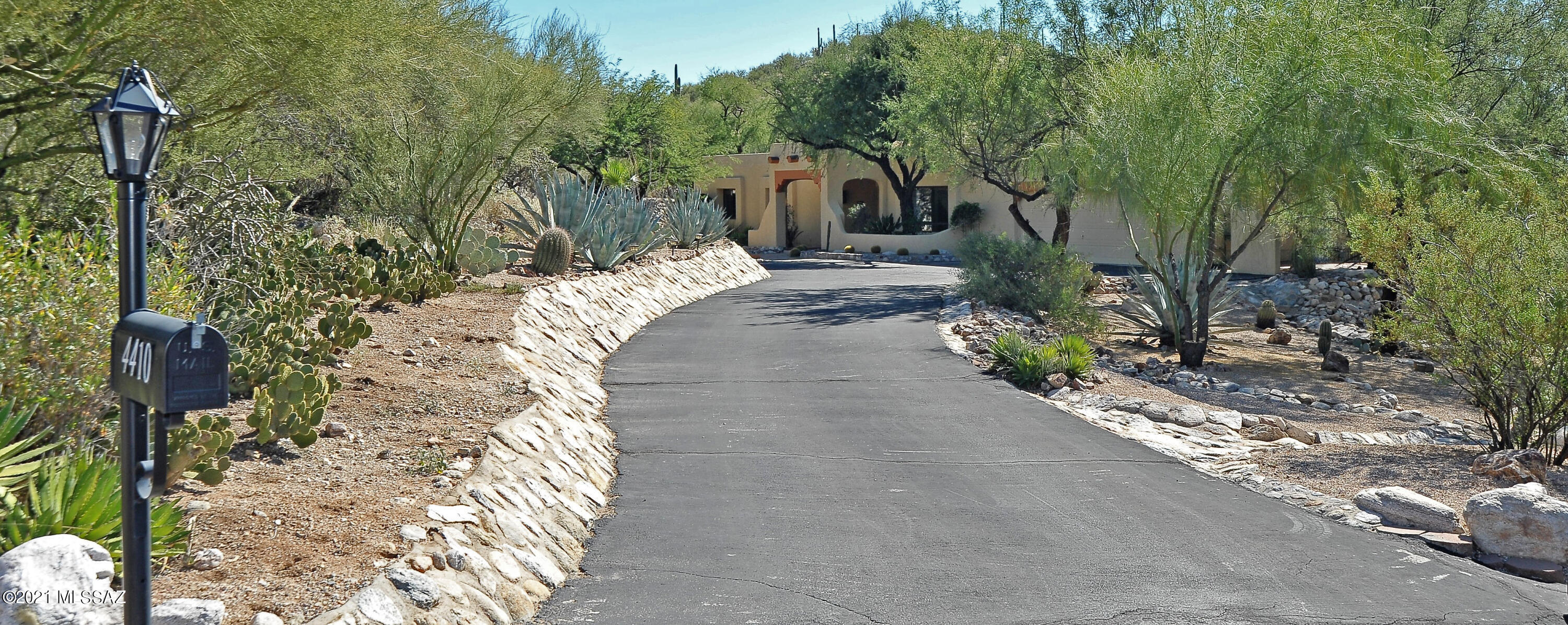Very special home with an amazing setting in the gated foothills community of Rockcliff! Santa Fe style masonry stucco construction with a pool on nearly an acre includes city lights at night! Custom touches include kitchen with brick accents & stainless appliances, wood & tile flooring, beamed ceilings, numerous skylights, built in shelves & brick fireplace at family room, wood interior doors & fireplace in master suite. Amazing entertaining yard overlooking a canyon with city views. Huge covered viga beamed ramada off pebble-tec pool/spa, built in BBQ,traditional kiva fireplace & grass area.  New carpet in bedroms,den off primary bedroom, 11 skylights, tankless water heater.  3 fireplaces total- 2 inside & 1 out. Trash service included as part of HOA. Don't miss this amazing desert home!