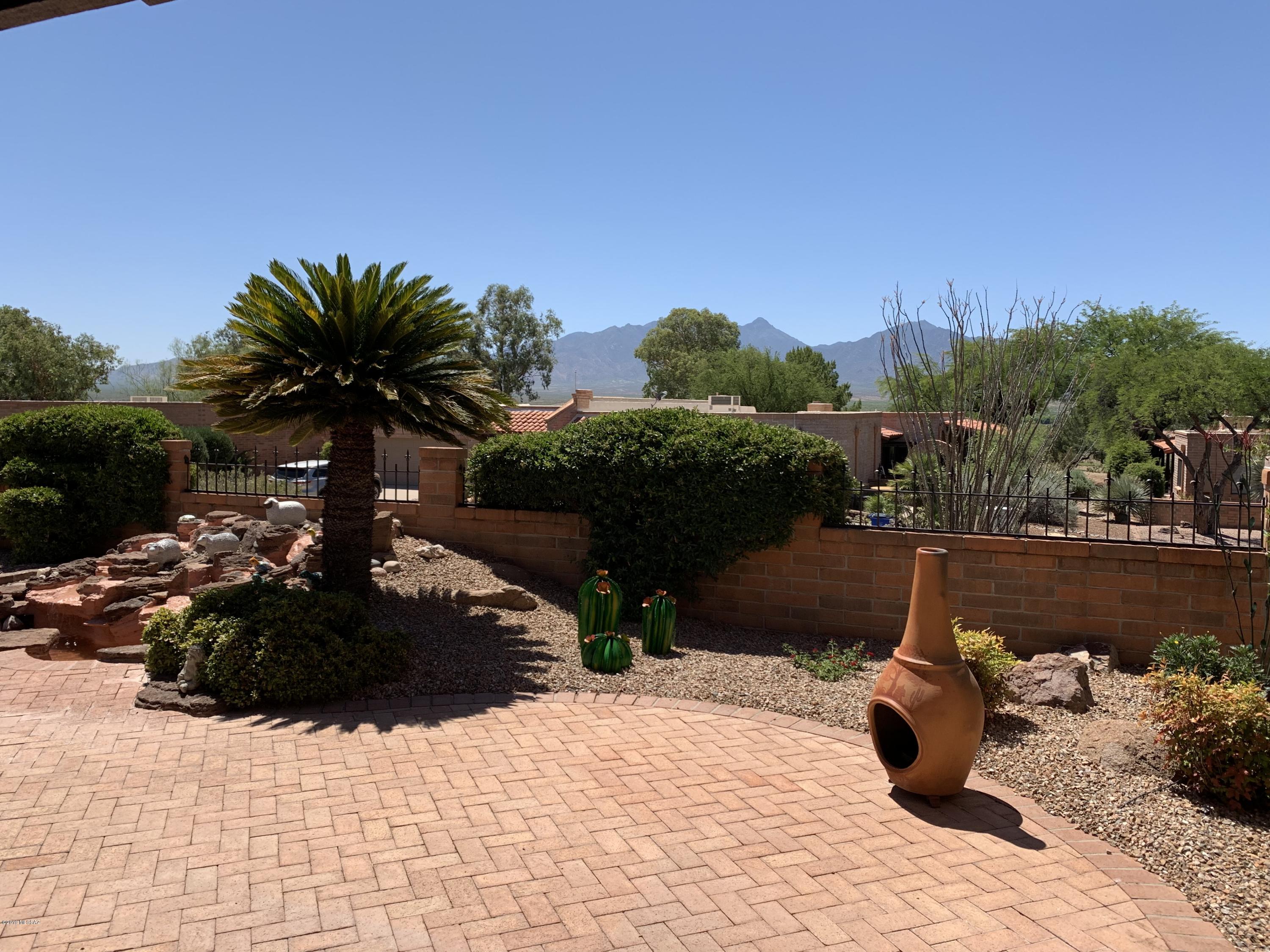 A tastefully updated townhome offer tons of space with breathtaking views of the Santa Rita mountain range. Step inside the home and your immediately impressed with the updated tile floor throughout the home. The kitchen boasts upgraded solid surface counter tops, stainless steel appliances and ample cupboard space for all your items. Off the kitchen, you have a formal dinning area with spectacular views to gaze at while entertaining guests. A beehive fireplace is the perfect anchor for the living room, which adds a true southwest flare. The master bedroom is expansive, with sliding glass doors and a view you'll love to wake up to each day. A second bedroom and bathroom for guest even has its own private patio. Outside you'll appreciate the fully covered patio to enjoy your private oasis.