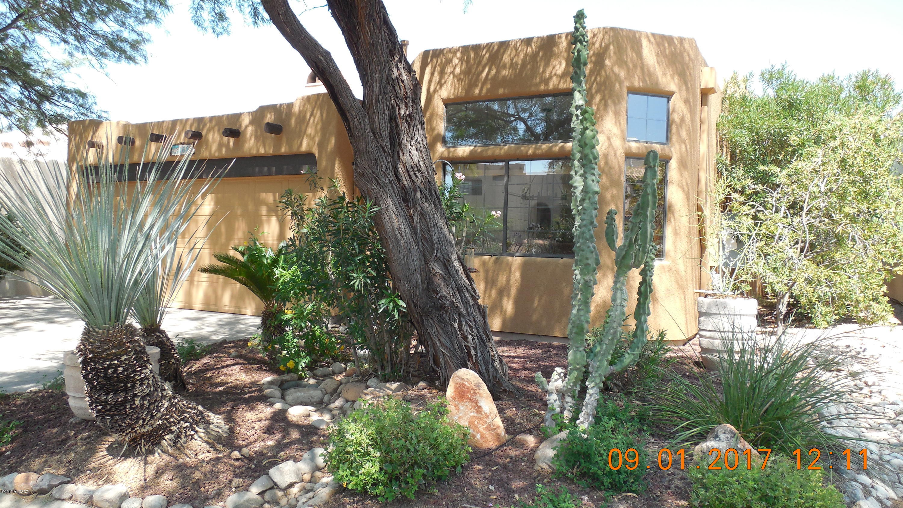 Charming one story Santa Fe style home nestled up against the Catalina mountains in La Reserve.  Guard-gated community.  Adequately maintained and modernizations with 12ft pecky-wood ceiling and viga beams, Saltillo tile, corner beehive fireplace, wrought iron fence.  Low maintenance landscaping with mature trees and incredible views of the Catalina mountains and hill top panoramic view of valley - only street in the development that offers this views.  Newer energy-efficient heating/cooling system with 3 year prepaid maintenance agreement. Thermo-Seal roof with warranty.  New water heater, solar screens and community pool and spa.