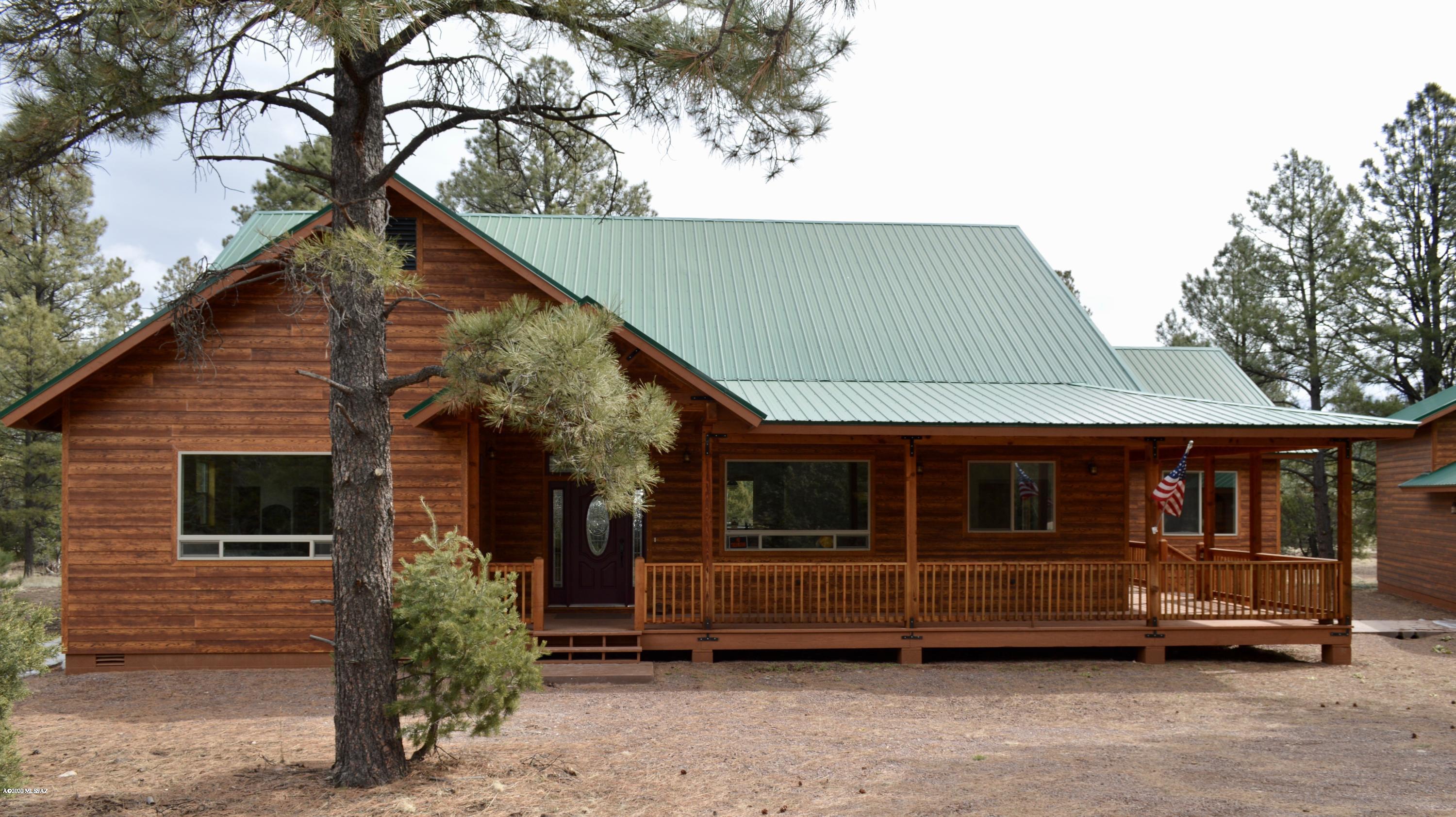 This spectacular custom cabin built in 2017 in the small town of Nutrioso AZ., home to abundant wildlife and popular among hunters, hikers, campers and fishermen.   This 3816 square foot home with 3 bedrooms and 2 and ½ baths boasts a spacious open floor plan with vaulted ceilings, custom cabinets, stainless steel appliances, granite countertops, mini-wet bar, and wood laminate flooring throughout. Enjoy two gas fireplaces, one in the family room and one in the master suite.  The master bath features travertine tile, a waterfall shower, a soaking tub, vessel sinks and large closet space. Finished 1000 sqft. basement would be perfect as a game room or extra living space. Enjoy outdoor entertaining on spacious front and rear covered porches. Detached 3 bay garage will house your two vehicles AND your RV.  Propane gas, 2500 gallon water tank connected to your own well, 75 gal water heater and cable TV/Internet top it all off.  All these amenities surrounded by beautiful forestry makes this property more than a getaway, it's a complete escape. Motivated Seller! Submit all offers.