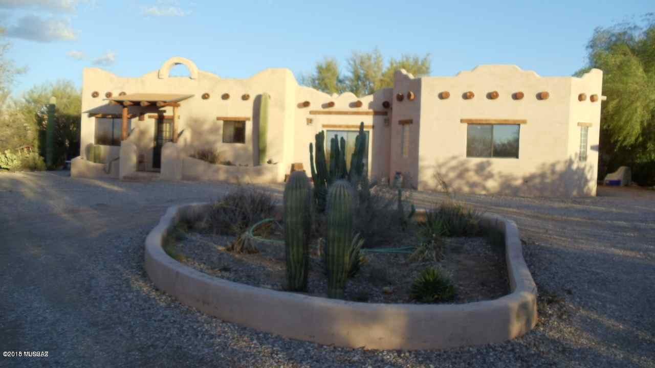 4 acres w/newer rustic masonry SantaFe w/pool and spa.Appx 650 sq ft rear covered porch.Super mtn and sunset views from home/pool area.Ramada w/outdoor kitchen.Walled in pool and spa area. Stable w/2 stalls,tack rm, hay storage. Corral/riding area w/ez access to Sahuaro Natl Park/riding areas Custom kitchen cabinets are rustic solid distressed alderw/lots of built-ins.Formica counters. 2 septics, ideal for outbuilding/ RV hookup (MH previously there)Avra Water Co (cheap) Home sold AS IS, priced accordingly as seller hasn't completed some minor cosmetic parts of the remodel. 2 HeatPumps new 2016/2017. New roof approx. 5 yr ago. Fireplace in master bedroom. Huge firepit . All 4 acres are fenced.Near comm pool,ballfield, soccer field, sr activity ctr