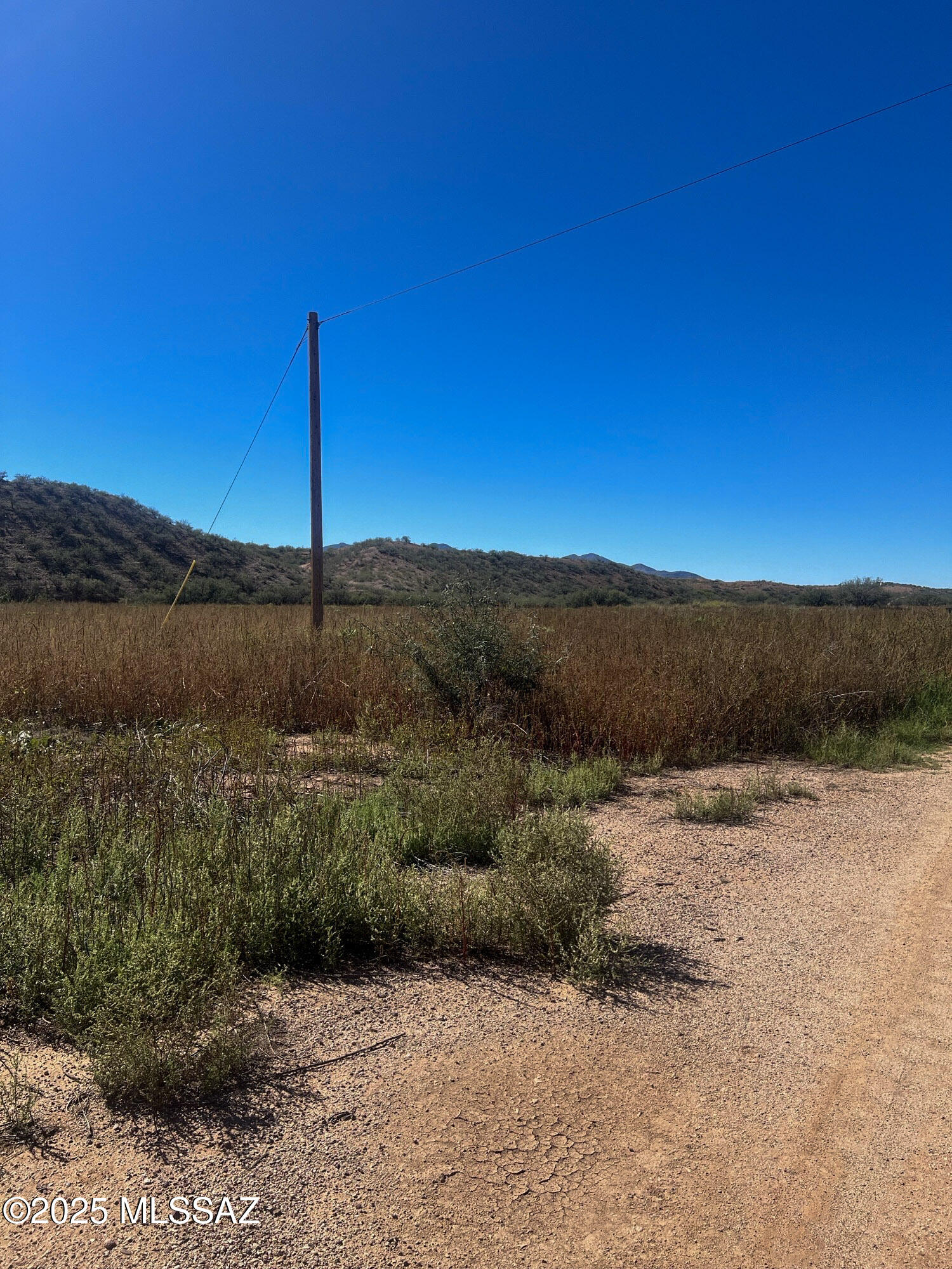 OWNER CARRY! BRING OFFERS! 7.54 Acres of prime land located just north of Huachuca City with electric, water (well share & tank) onsite, and views of the mountains. The well sits on an aquifer that runs from Utah and delivers 18 GPM, with testing available to buyers. Will need septic and propane, but is ready to build on surveyed/staked flat topography, fully fenced, with soil testing done and a private gate shared with a handful of other parcels--zoned R-1, which allows only stick/site-built homes but can be split and accommodate horses. A must see!