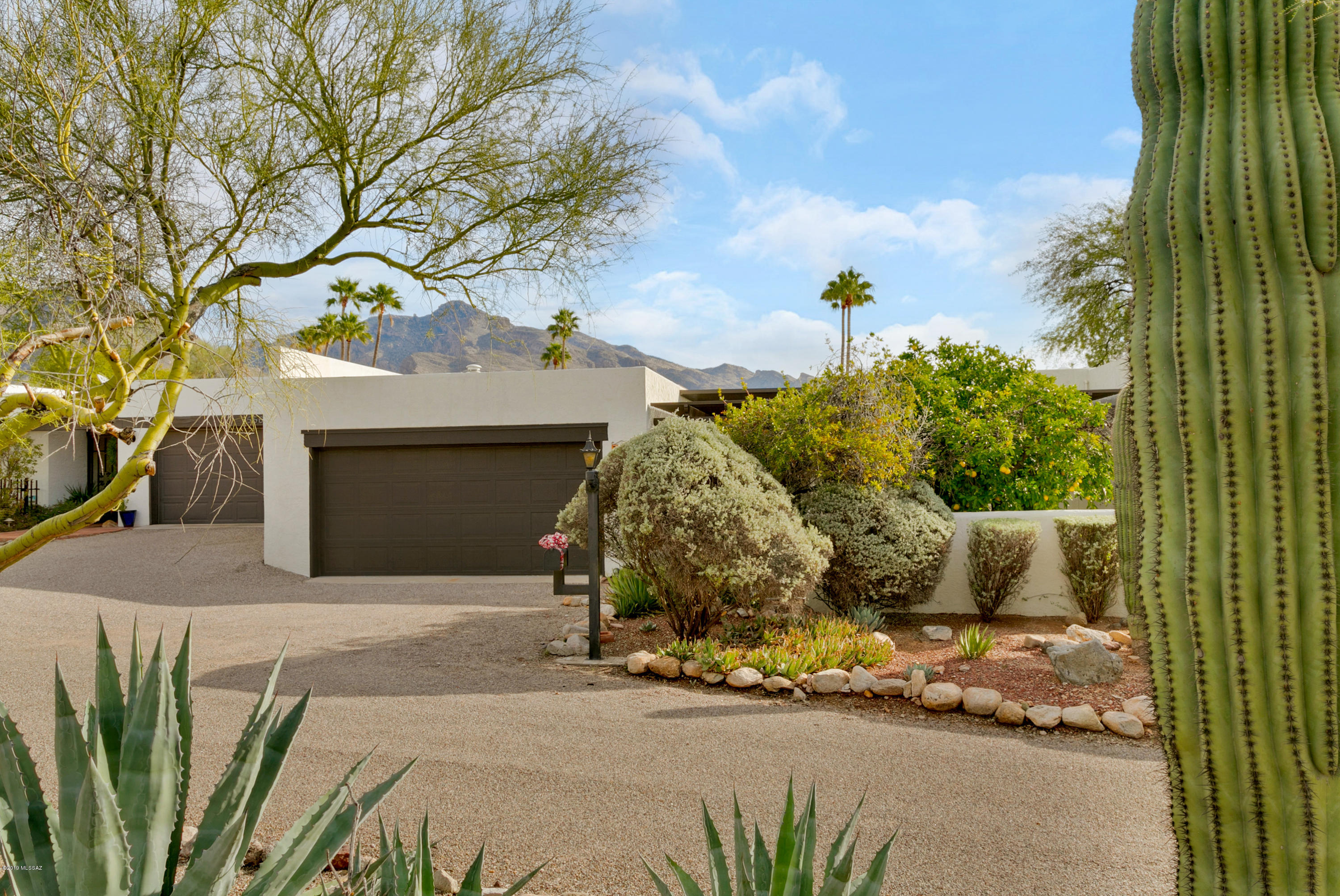 Located in a desirable intimate community next to the Westward Look Resort, this town home features Catalina Mountain views a courtyard entry, 2 covered patios & privacy. Scored concrete floors throughout & a concrete kitchen counter-top, & fireplace. The kitchen is spacious with a center skylight.  You can convert the family room into additional bedroom space for company with a privacy curtain and wall bed which stays. Natural gas BBQ stays. The master bedroom features a spacious walk-in closet and access to the patio. This home is a must see. New roof in 2019, New gas pipes in 2013, upgraded electrical, HVAC in 2010.. HOA includes trash pick up, cable, spa and pool heated all year round, club house, private roads, & landscaping of common grounds.  Open House Dec 15 from 2pm - 4pm.