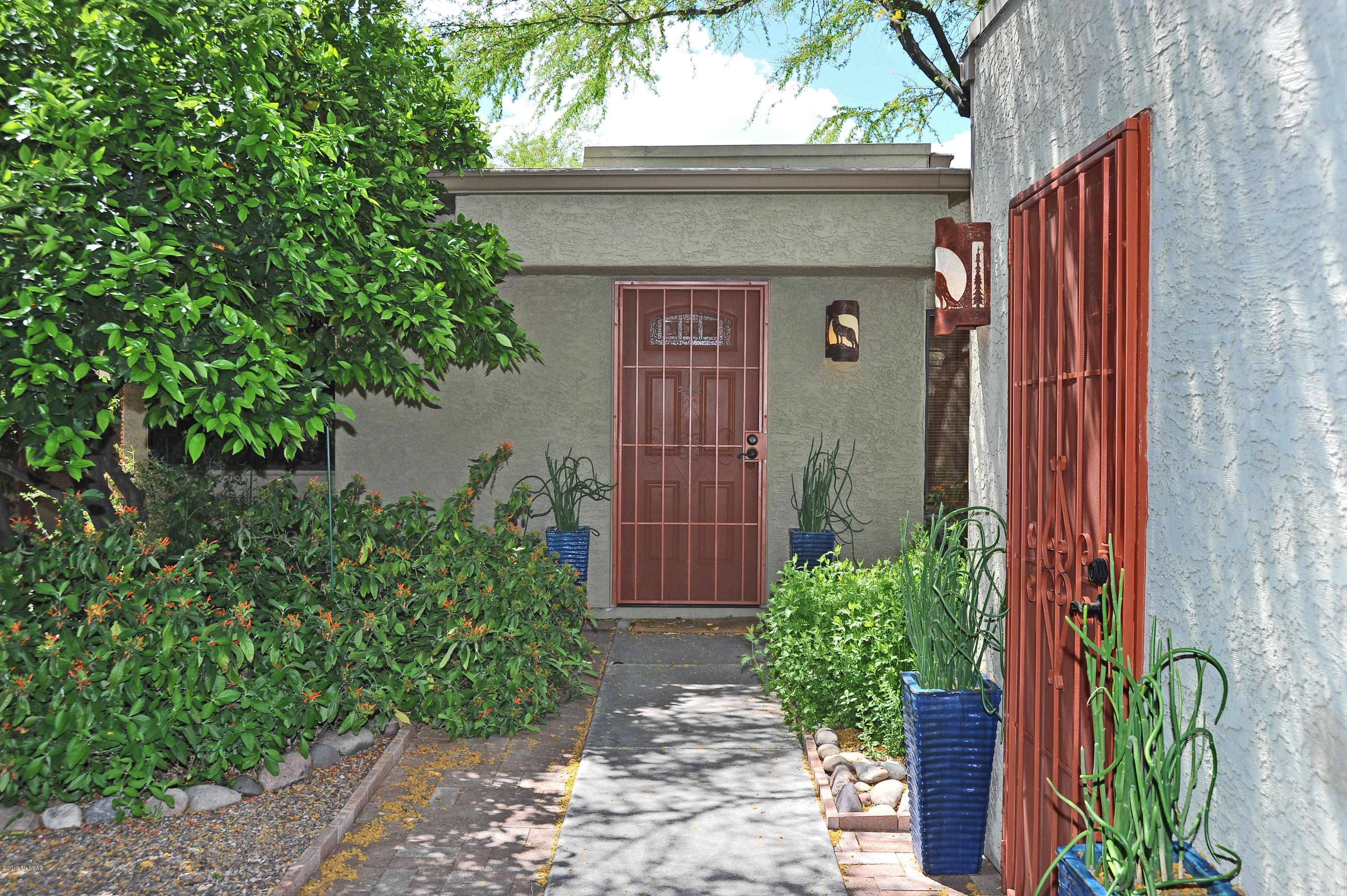 Incredible location along the Rillito River Park and Bike path.  Amazing courtyard garden oasis using Water-Harvesting and Xeriscaping with Low Water-Use Watering System.  Brick Patio with Ramadas, Awnings, Bamboo Window Shades. . A finished 2 car garage with insulation, cooling, lighting and a security door (options for extra living space, workshop, studio, secure and clean storage, and a posh place to keep a car, garden tools, and bicycles.Newer Air Conditioner/Heater, Newer Hot Water Heater, New Kitchen Appliances.New Water-Harvesting Tanks and New Gutters. New flooring in living room, dining area, kitchen, and bathrooms . Move in Ready in Great condition. Community pool, ample amount of extra parking. Orange Tree, Pomegranate Tree, Sweet Acacia Trees, Mexican Honeysuckle. Low Bills Native Plants that feed:
Hummingbirds, Butterflies - Monarchs and Swallowtails, Yellow Finches and Cardinals. 
Orange Tree, Pomegranate Tree, Sweet Acacia Trees, Mexican Honeysuckle and Various kinds of Penstemon