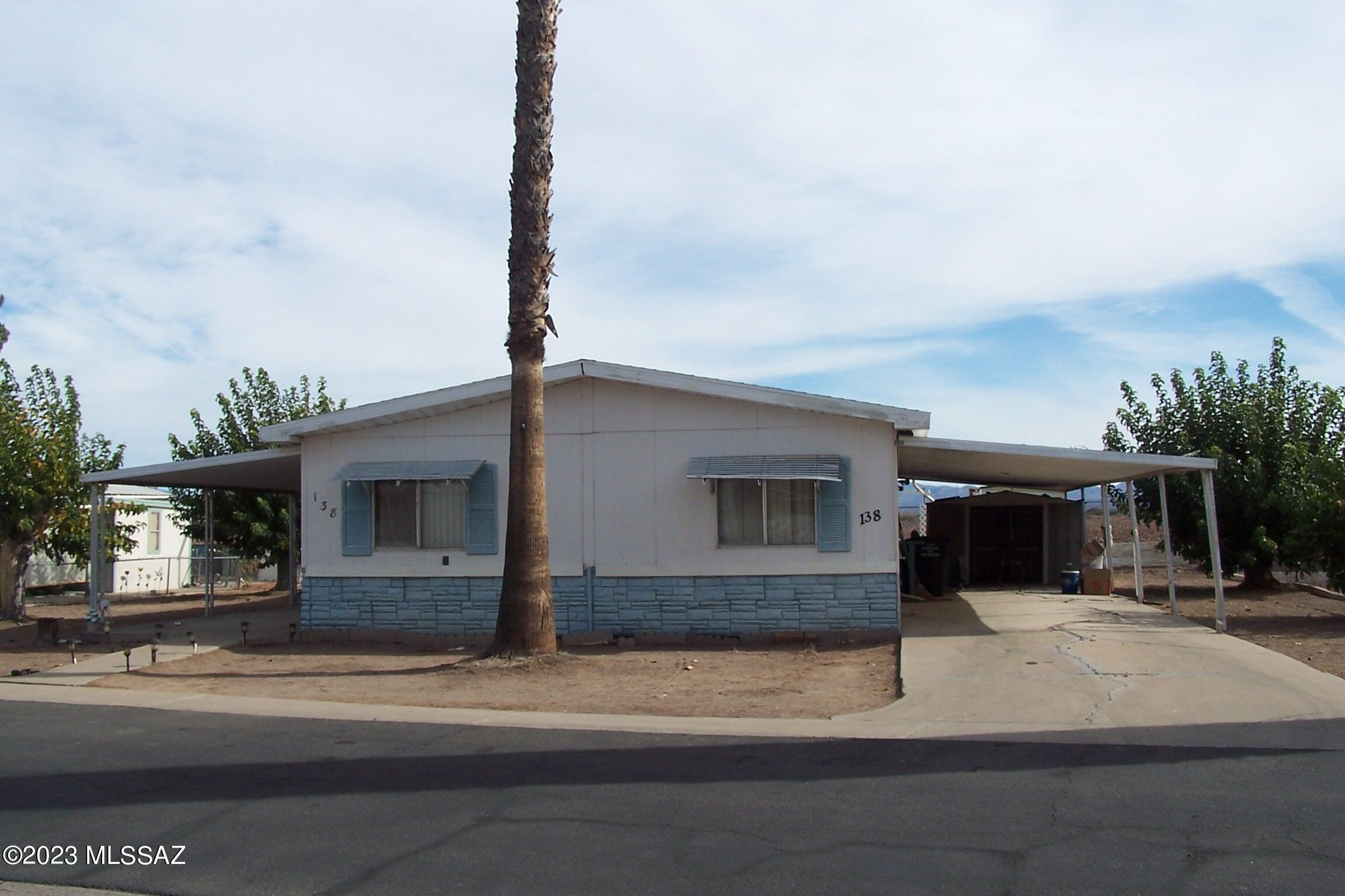 Nice large double-wide on a double lot in Safford Ranch which is a 55+ community with pool, community center and more.  This home has living and family room, tons of storage, eat in kitchen along with formal dining room and built in hutch.  Large primary bedroom with really nice size closets, bathroom has soaking tub and stand up shower.  Large Laundry room with desk and storage.  There are a few outside storage buildings and covered parking.  Nice mature trees on the lot.