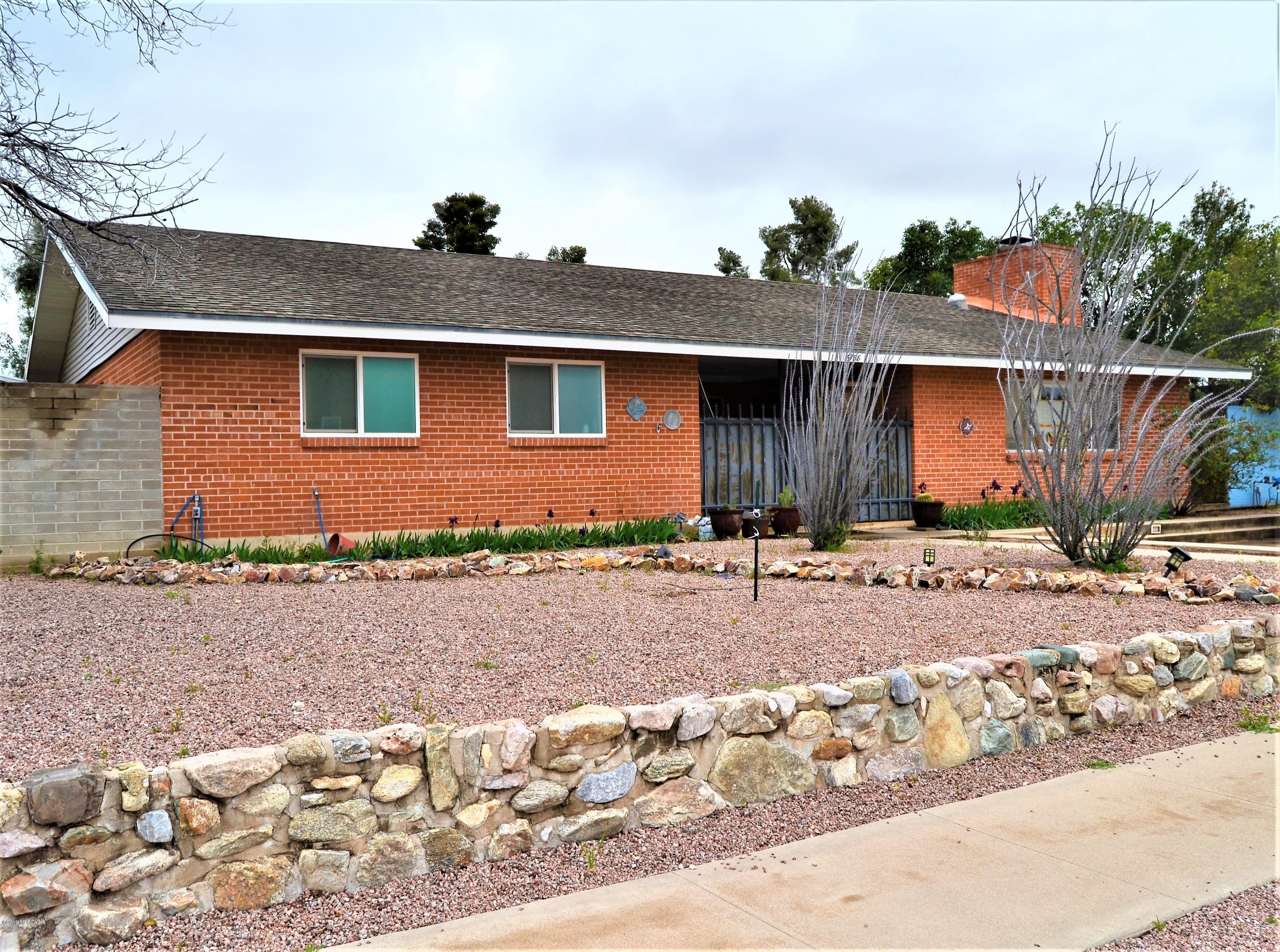 Large home with a cabin feel in Terra Del Sol. Enjoy the Great Room with a gas fireplace centered in a stone wall and hearth.  This red brick home boasts 3 bedrooms, 3 baths, a large kitchen with room for island or casual dining table, Arizona Room, formal dining room, leased solar, and a detached garage/workshop.  Situated on the corner, this .25 acre lot provides ample room for backyard fun and entertainment.  Home has a 1.5 car detached garage off alley and two off street parking spaces in front.  Walking distance to the local park, elementary school, and neighborhood pool facility.  Close to shopping and easy access to DMAFB.  Your new home is waiting.  Stop in and see what Terra Del Sol living is all about.