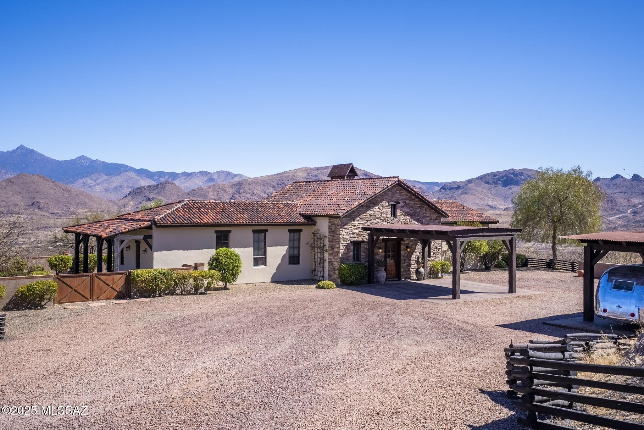 Tucked inside the exclusive gated enclave of Morning Star Ranch, this 36-acre estate offers the perfect balance of privacy, luxury and wide-open Southwest beauty. Protected views of the Grosvenor Hills and Santa Rita Mountains bring the outdoors in, while maintaining a refined rustic elegance. Open-concept great room is anchored by a dramatic fireplace, tile flooring and exposed beam ceilings; chef's kitchen flows seamlessly into the gathering space, ideal for entertaining or quiet evenings in. Primary suite features fireplace, spa-like bath and private mountain vistas. Sprawling outdoor courtyard extends the living space with shaded areas for relaxing, stargazing or hosting. Horses are welcome, and with 36 deed-protected acres, there's room here to create your own private sanctuary.
