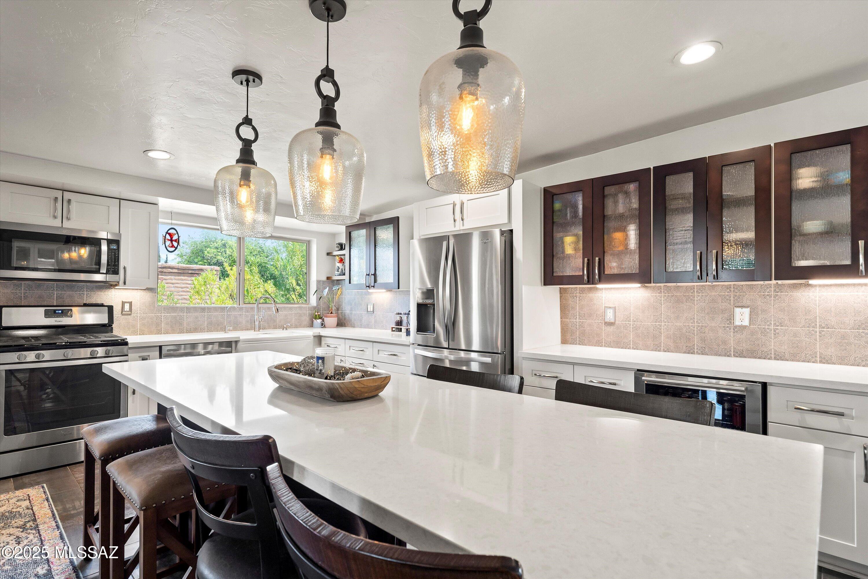 UPDATED 4BD/2BA Eastside gem on nearly a quarter-acre with a 2-car garage + 3-car COVERED parking = 5 covered spaces total! This is the home you've been waiting for. Open-concept split floor plan, tile throughout, and wood floors in bedrooms-no carpet. Dream kitchen with 9-ft island, beverage fridge, pullouts, built-in desk & custom backsplash. Renovated baths, dual-pane windows, new HVAC, and resurfaced cool deck. Heated pool, replastered, w/ dual-speed pump. Entertainer's yard: heated/cooled pool house w/ kitchenette, heated outdoor shower, waterfall, REAL grass, pavers, NEW awnings, and lush landscaping. No HOA! A MUST SEE! Schedule your tour TODAY!
