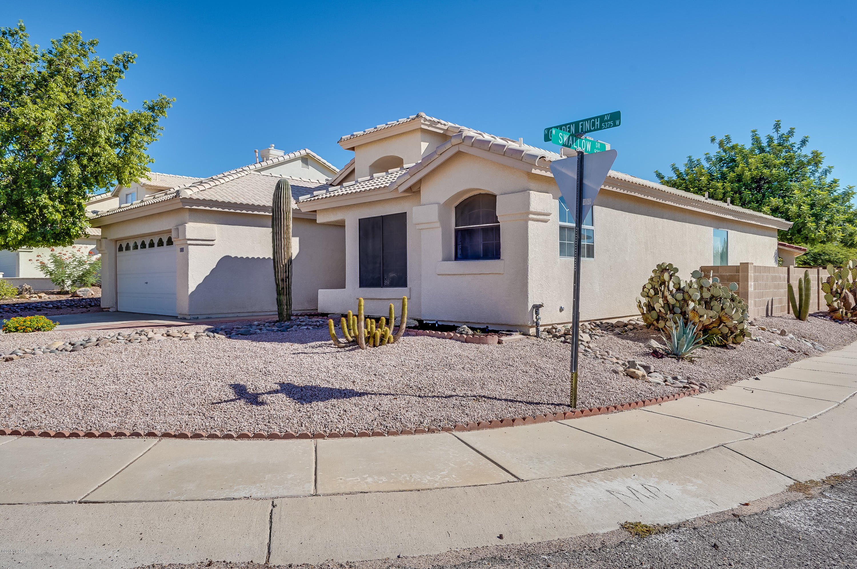 Amazing 3 bed, 2 bath home situated on a corner lot that provides views of the Tucson Mountains. The inside of this home looks new, thanks to freshly painted interior and cabinets, along with new carpet. As you walk in the front you are welcomed by the shy high vaulted ceilings in the living room accompanied by a fireplace. This home also features a split bedroom floor plan, no HOA, plumbing warranty, home warranty, and NO POLY!