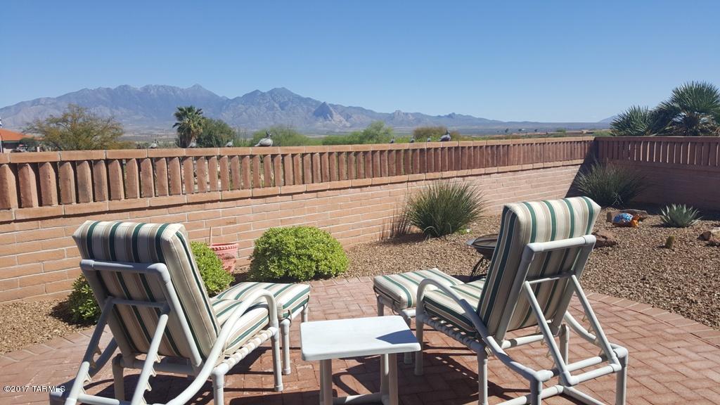 Beautiful popular and expanded Jasmine floor plan with a den shows like a model home and is available fully furnished. The split floor plan features the second bedroom and full bath with a privacy pocket door. 2 master suites! Light and bright kitchen with white cabinetry, SS appliances, contrasting black granite counters and a great view of the Santa Rita mountains. The spacious den has a closet and could be converted to a third bedroom or large office or crafts room. The tiled patio has automatic shades as well as the breakfast nook with its own automatic awning. Enjoy the privacy and mountain views in the back yard with the extended height walls. Furniture is offered by separate bill of sale, please ask your agent for our inventory sheet. Ready for quick occupancy.
