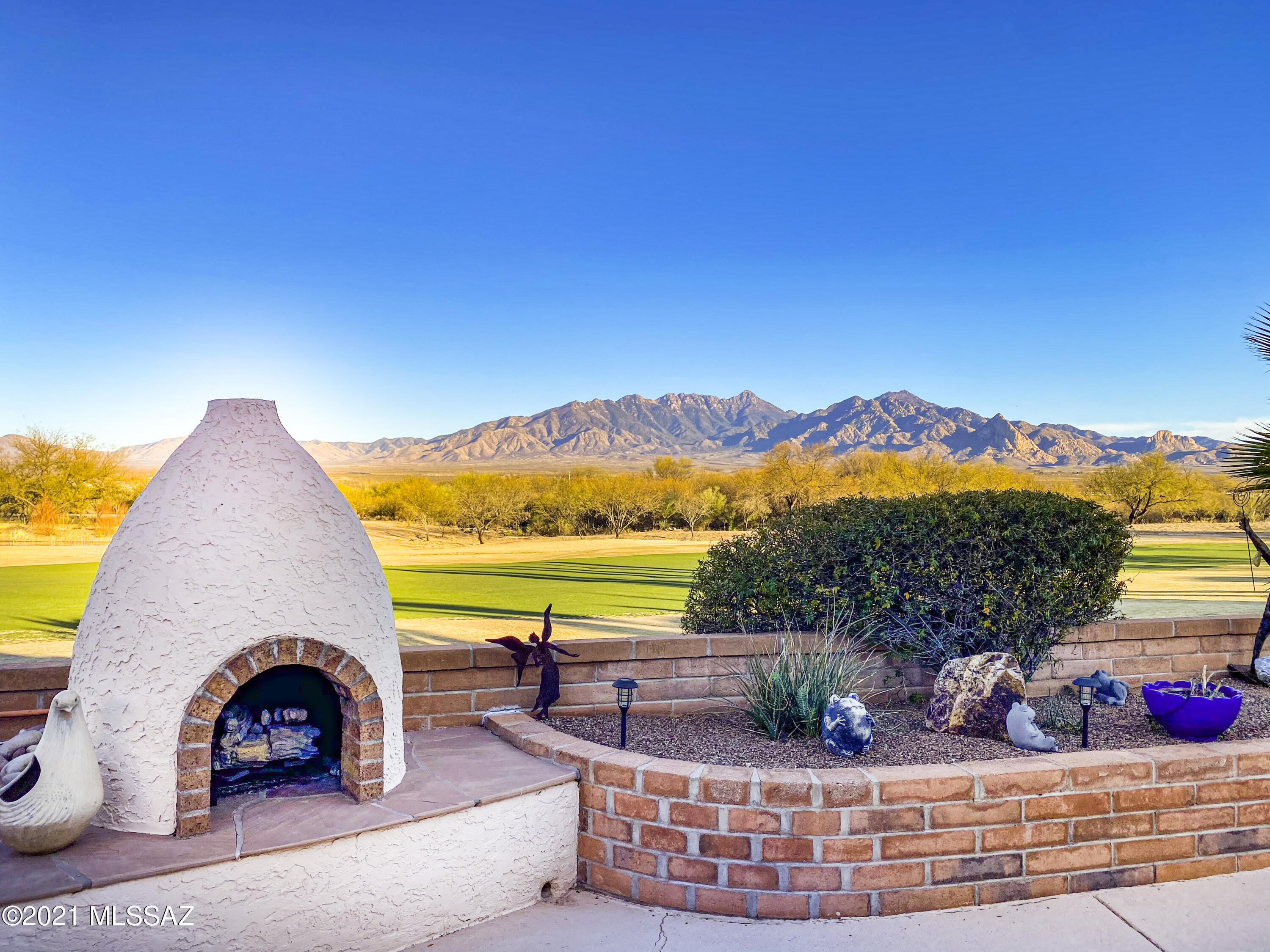 Beautiful landscaping and a gated front courtyard welcome you into this exceptional Green Valley residence. Inside, the living room with warm paint colors, soaring ceilings, elegant tile flooring and a cozy fireplace flow into the family room with expansive views through a wall of glass. The spacious kitchen features white cabinetry, contemporary backsplash, double ovens, tons of counter space and a convenient center island. For more intimate affairs, the formal dining space is ready for large gatherings and the wet bar is just around the corner. Retreat to the master suite complete with sitting area and a large bathroom featuring dual sinks, a soaking tub and a generous walk-in shower. Your guest's suite is the perfect place for them to have additional privacy during their visit. The outdoor living spaces are exceptional offering a built in BBQ, gas beehive fireplace and spiffy spa. The setting is second to none - jaw dropping views of the golf course and Santa Rita Mountains will be yours to enjoy every day!