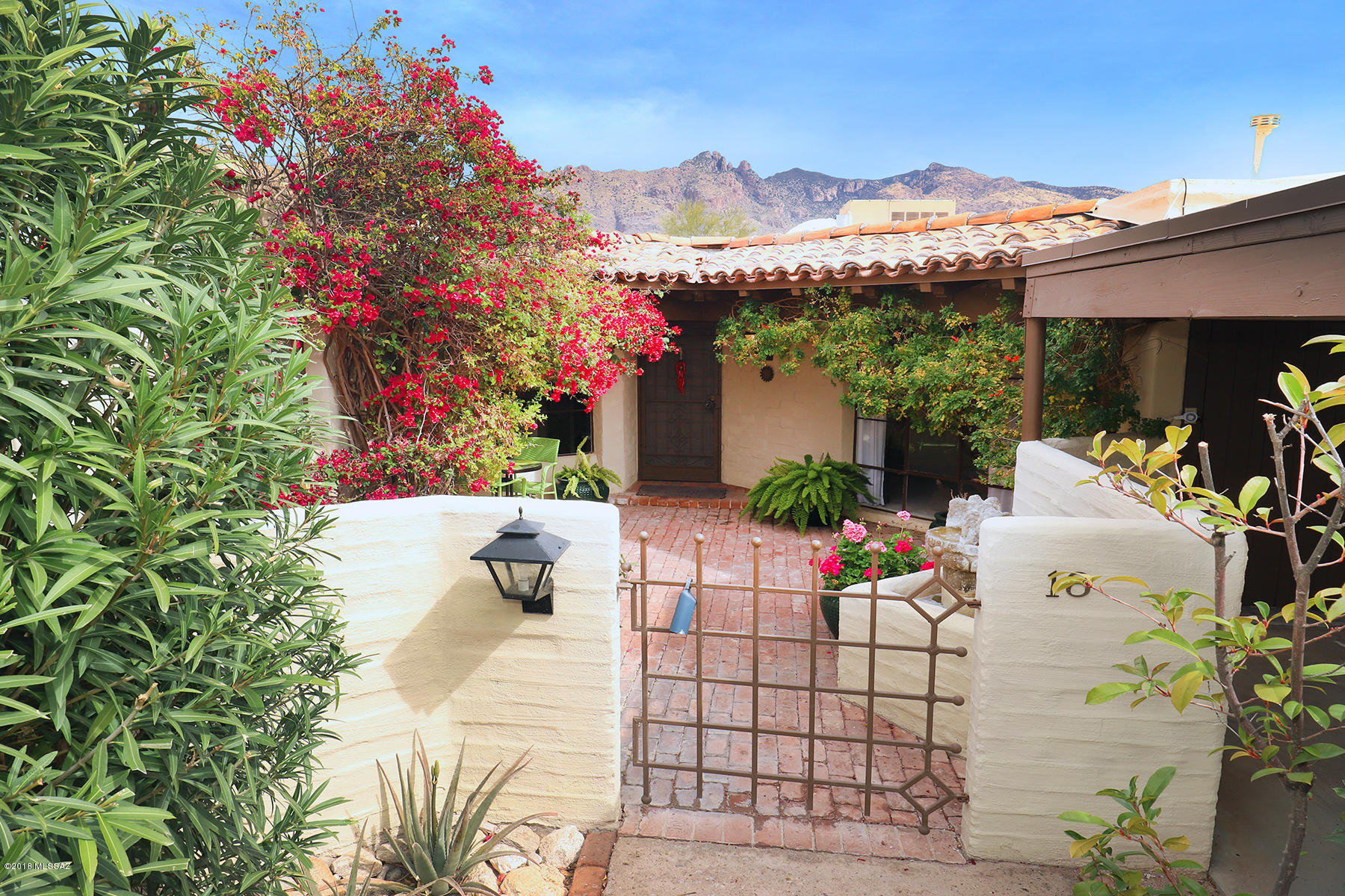 Located in a small historic neighborhood on 5.5 acres, these homes were built Juan Worner Baz, the successor of Josias Joseler. The home features a courtyard entry with a fountain, & mountain views in a tranquil setting. It is a an example of Baz's creative use of space and angles.Saltillo tile floors, lots of storage, wood fireplace & original charm. Floor to ceiling windows frame the views.Feels like a town home but organized as a Condo complex where everything is covered such as roof,exterior paint, water, roads,fire insurance,common areas. Property taxes will be much lower in the future as owner has received historic status. Gas and Electric bills are low. Community features a pool,koi pond, walk-ways,lush landscaping & a laundry facility.