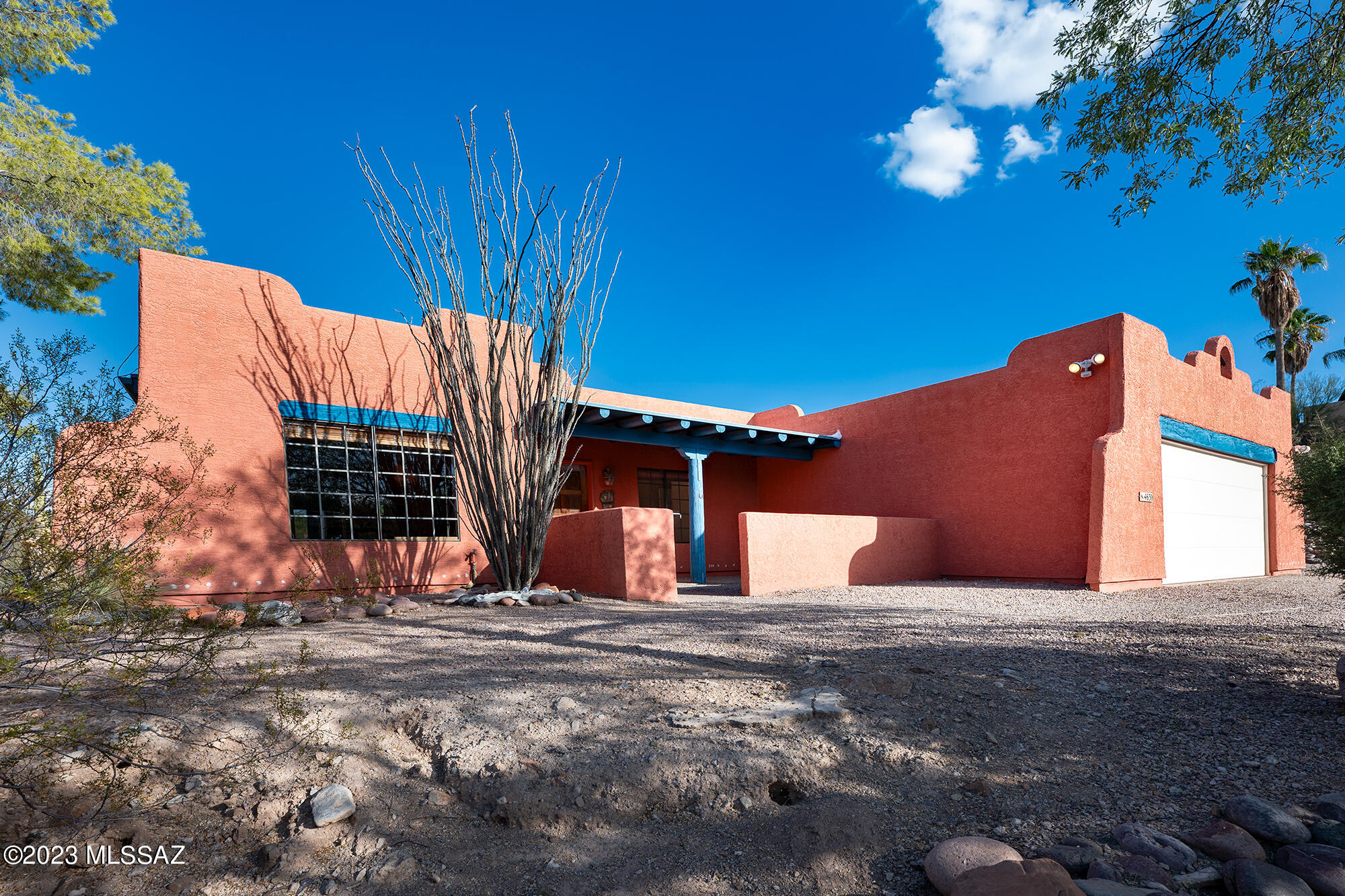 Santa Fe home in a private setting located on a 1.2 acre lot with Catalina Mountain views. Set back from the road, the charming home boasts character but will need a bit of restoring here and there. The home has good bones and a nice floor plan with 3 bedrooms plus den. Gated courtyard entry with Viga beamed covered front porch. Step inside to find tile flooring throughout,(carpet in 1 bedroom) a large living and dining room space with soaring ceilings. Double doors to the den with built in shelves & desk. Kitchen with oak cabinets needing some tender loving care and priced with this in mind.  Breakfast area and family room located off the kitchen. Sliding door leads to a lovely porch with double brick construction, Viga beam ceiling, security screens & beautiful Catalina Mountain views. Double doors lead to the primary bedroom with sliding door to the screened-in porch. En-suite bath with double sink vanity and garden style tub/shower. The well cared for home has a 2015 Tempstar gas HVAC serviced 9/2023, Water Heater 2015, Roof re-coated October 2023 with 2 year transferable warranty. Transferable termite warranty with Rigo Pest Prevention until October 2024. 12' of sewer line replaced Jan 2022. Space and electric  for RV.  Backyard with adobe brick wall. Home needs cosmetic work and is being sold in as is condition. Add your own touches to make this your home sweet home.