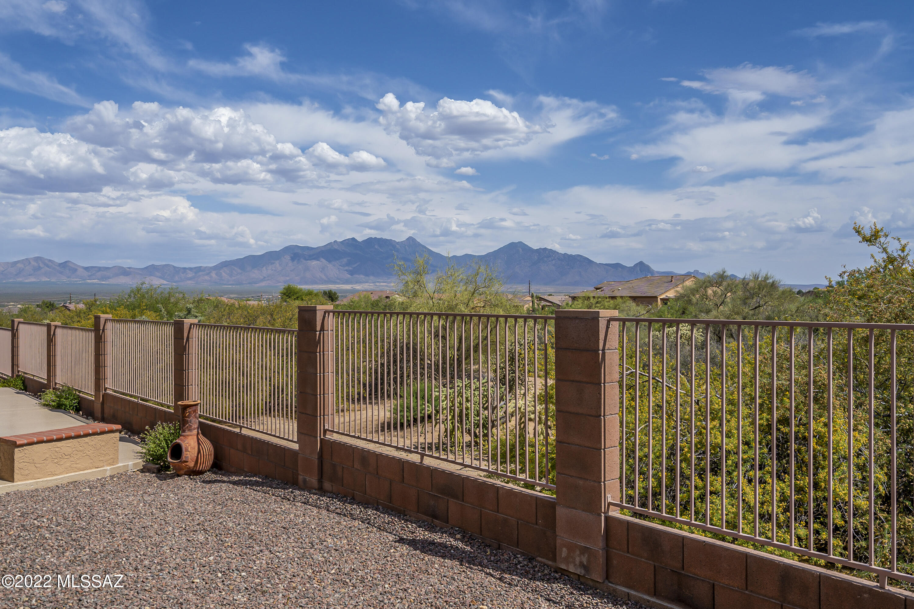 Simplify your lifestyle in Las Campanas Village!  This single-family home shows just like a model home and has an incredible location with views of natural desert behind the home and unobstructed views of the Santa Rita Mountains to the East.  Enter into the foyer and you will immediately notice the attractive tile floors laid on the diagonal throughout the home, cathedral ceilings and plantation shutters.  The living room opens to a dining room that is a place special place to converse with friends and family.  The cook's dream kitchen has an abundance of cabinets, gorgeous granite counters and a large serving island with decorative pendant lighting.  The adjoining family room has a corner fireplace and built-in media center and plenty of room for a casual dining table.  You'll appreciate the extending living space in the screen patio where you can enjoy panoramic views of natural desert, watching the sunrise or sunset and of course, admiring view of the majestic Santa Rita Mountains.
