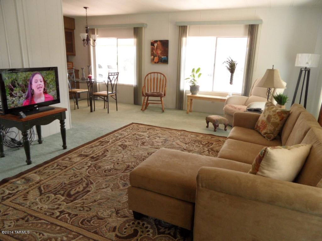 Approx. 1/2 acre lot in an all adult gated community of 8 homes. Very unique, charming,2 bdrm 4 bath well kept dbl wide mobile home w/Az room and a separate 480 sq ft guest house. New A/C heat pump,front and rear porches,large fenced yard in a very desirable NW area. Plenty of room for RV and yes, pets allowed. Don't let the year of the home detour you. It is in mint condition and has been well maintained. This is a CO-OP parcel that was grandfathered in since 1950's. Taxes are divided by 8, so they are very low. It's a lovely, affordable home, with country feeling but close to hospitals, shopping and golf. There's no other place like The Lazy 8 Ranch.Call to view.