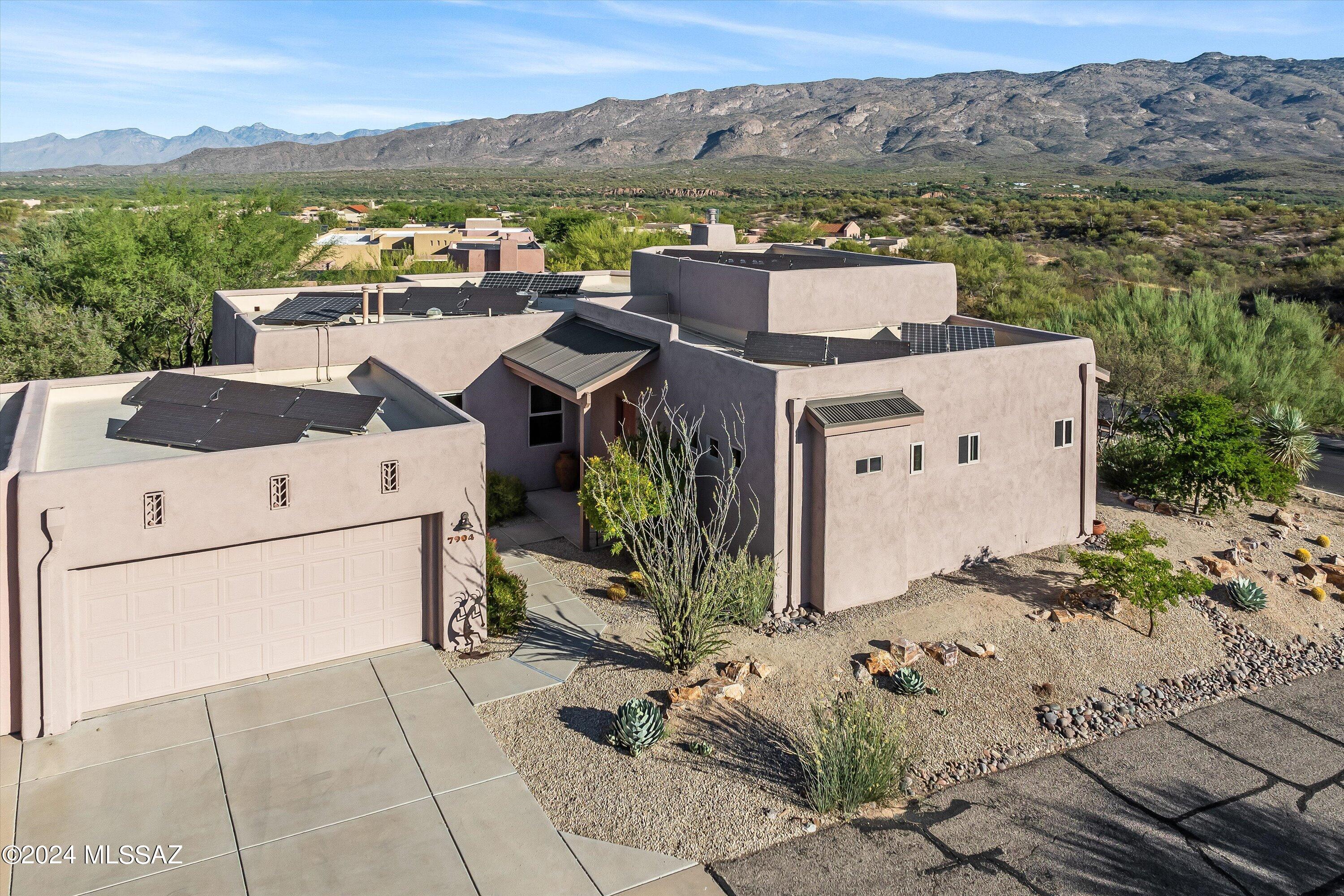 Amazing views from this elevated lot!  Large picture windows overlook the Rincon and Catalina mountains.  High ceilings (14' in the living and dining room), and tile floors throughout, plus a spacious open floorplan.  The kitchen features premium, upgraded cabinets, lots of storage including a pantry, island, and a spacious breakfast area,  all this overlooking the family room with a fireplace.  The large main bedroom has terrific views, guest bedroom is spacious as well.  The office is open for the view, or use it as a den with a TV.  On the roof you will find  a 5.22 KW solar system for low power bills, plus upgraded windows, new exterior paint, and a newly recoated roof.  This 55+ community is loaded with activities including a heated pool, crafts, live music, classes and lectures.