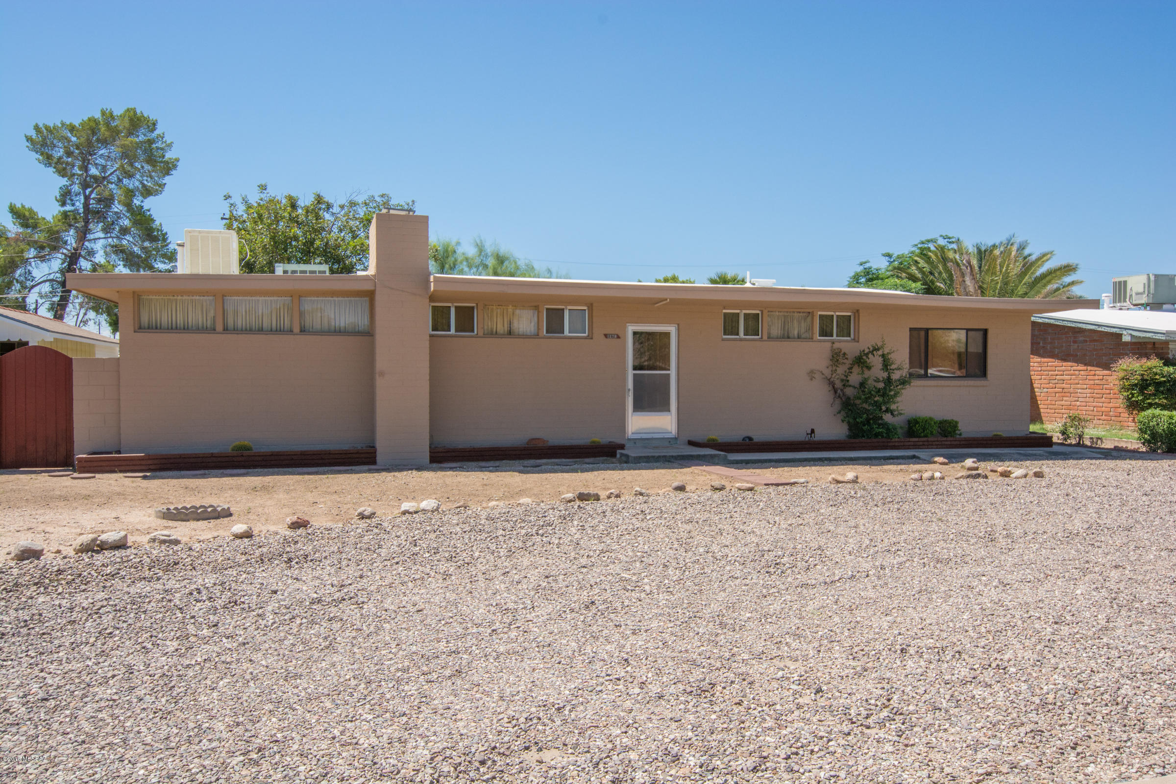 This charming home on a quiet cul-de-sac off Mountain Ave near the UofA comes with a cozy corner fireplace, a sit down kitchen bar and extra cabinets. The Arizona room off the kitchen leads to a 3rd bedroom with a/c & heating window unit and 2nd bathroom. The master bedroom fixed window has a rolling shutter. The spacious yard is enclosed with a block wall and has 3 storage sheds. A New roof, front door and fresh exterior paint was added in August 2017. New sheet flooring in kitchen & Arizona room were installed in April 2018.