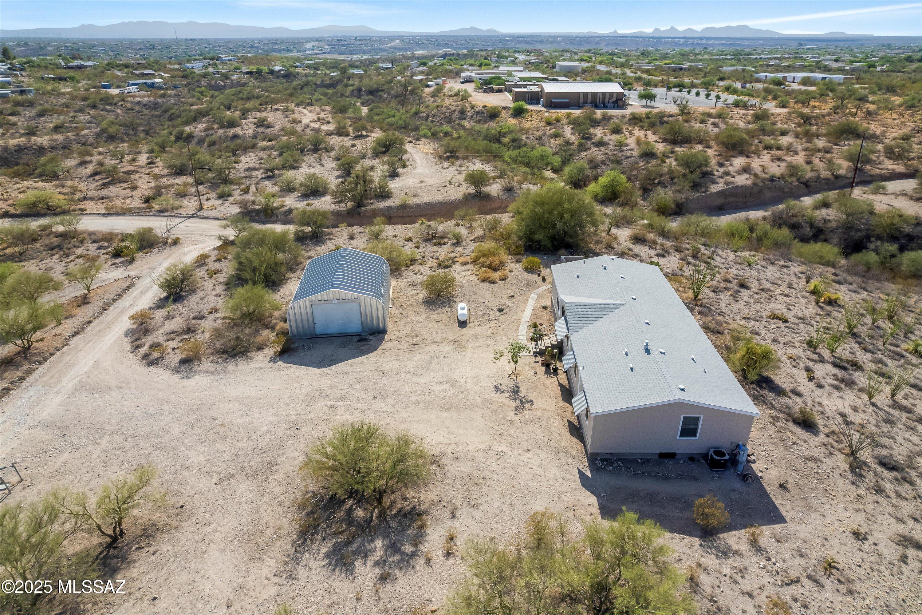 0-3% DOWN PAYMENT OPTIONS AVAILABLE—ASK US ABOUT IT! See Documents Tab for flyers. Make the most of desert living in this spacious 5 BD/3 BA affixed manufactured home on an elevated 1-acre lot in the desirable 85641 zip code. Built in 2002 and lovingly maintained by the original owner, it offers masonry skirting, well water, a whole-house filtration system, and a new 2021 roof. The north-south orientation captures stunning mountain views and abundant natural light. A detached 22'x31' two-car garage/workshop with 220-amp electric adds versatility, while a backyard firepit is perfect for cool Vail nights. Located in the top-rated Vail School District with no HOA.