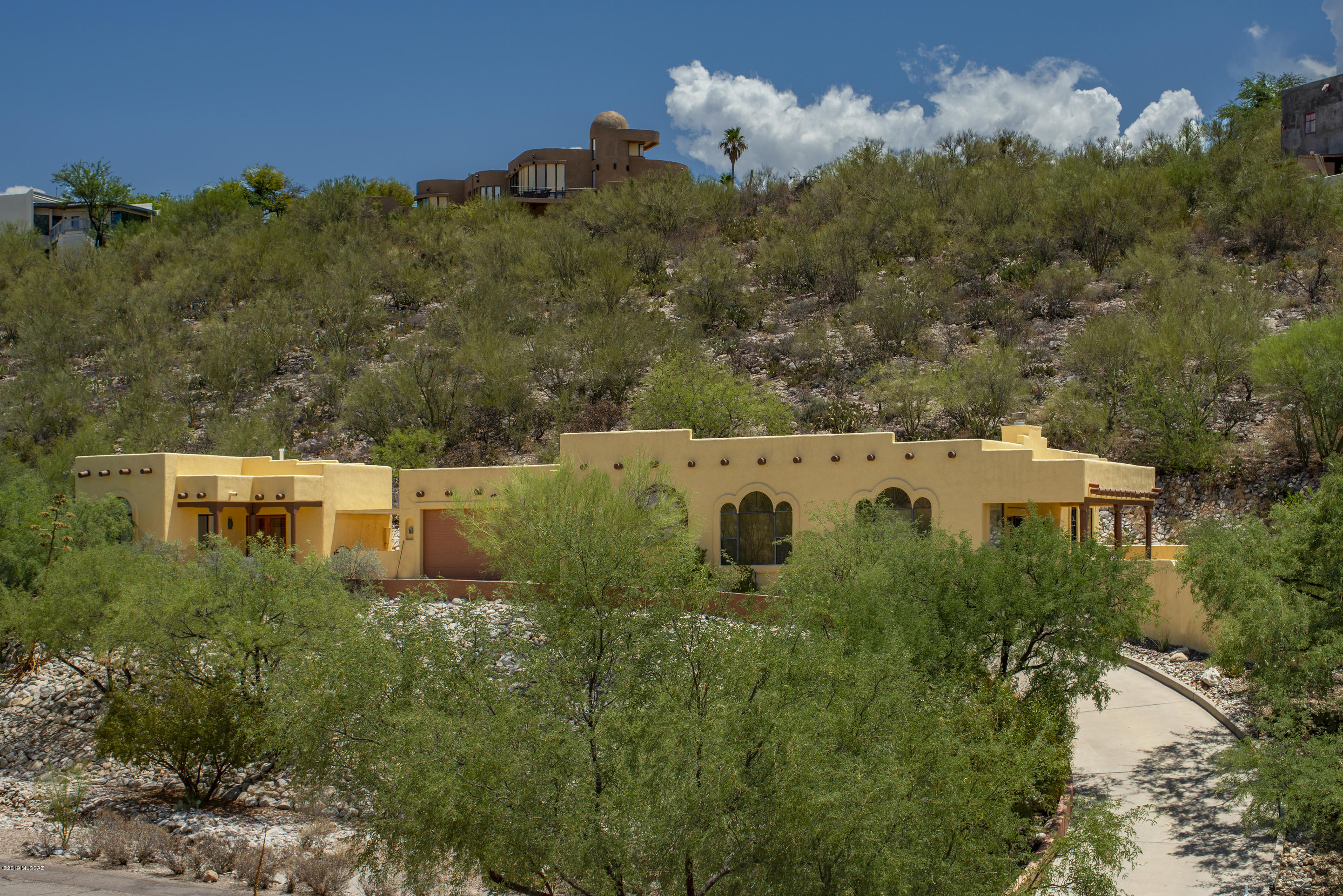 Stunning Hillside Santa Fe, 2179 sq ft Main House-3 Br & Den/& 2 Full baths.  Spacious Kitchen with Viking Stove-Eucalyptus/Bamboo Cabinetry. Large Master Suite/bath w/2 Extra-large Walk-in Closets.
Handsome Great Room with Beehive FP & High Open-Beam Ceiling.  Concrete & Carpeted Floors. Plantation Shutters throughout. Grand City, Sunset & Mountain Views. Beautifully done 695 sq ft Guest house w/Living rm, Bedroom, full Bath would make a great Office, Studio or Student/Mother in Law Quarters. Large2+ garage w/wall of cabinets, great storage. Freshly Painted, Newly Carpeted, End of cul-de-sac in Quiet Neighborhood. Half Mile to Basis, Whole Foods, Restaurants and more.
Relax on your Covered Patio at Sunset:
Enjoy Nature and the View. The HOA fee is $175/year.